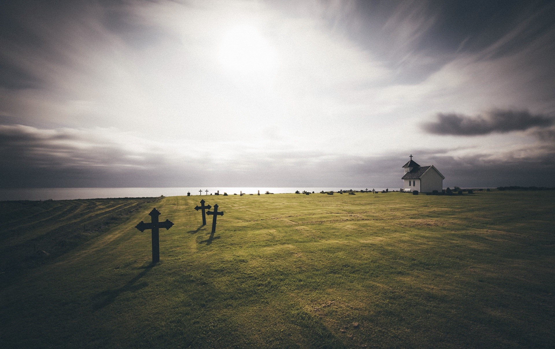 Cemetery with crosses and church by the sea in Norway HD Wallpaper