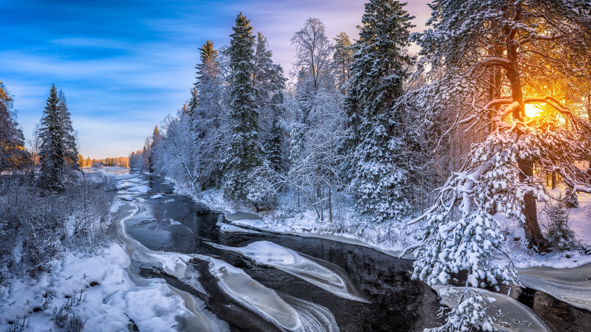 Winter river flowing through a snow-covered forest at sunrise HD Wallpaper