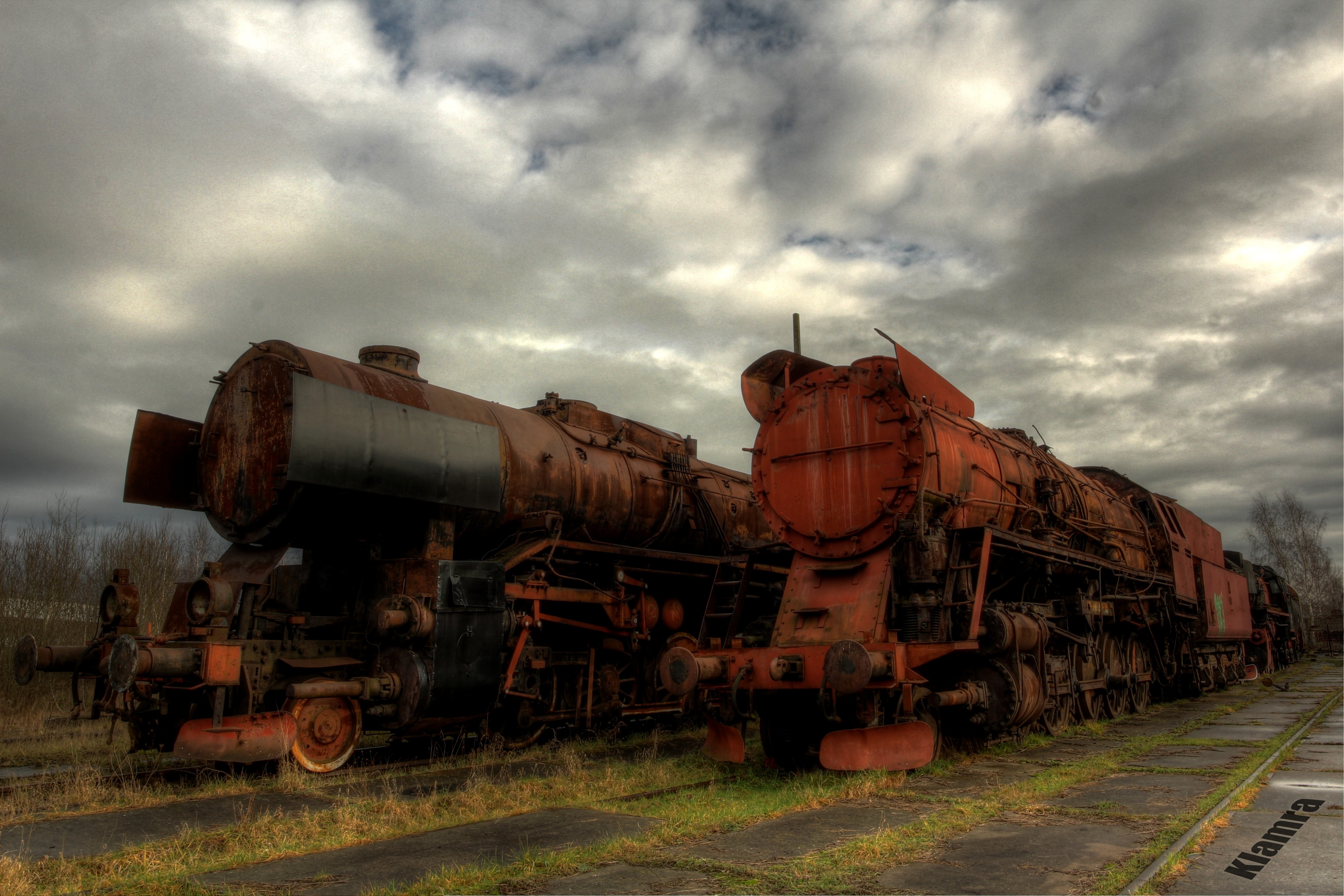 Abandoned steam locomotives in Poland under cloudy sky HD Wallpaper