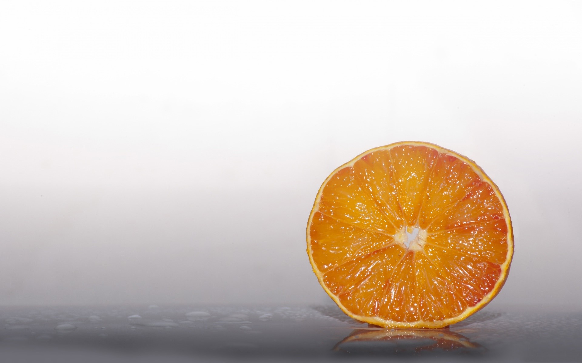 Slice of orange on a reflective surface HD Wallpaper