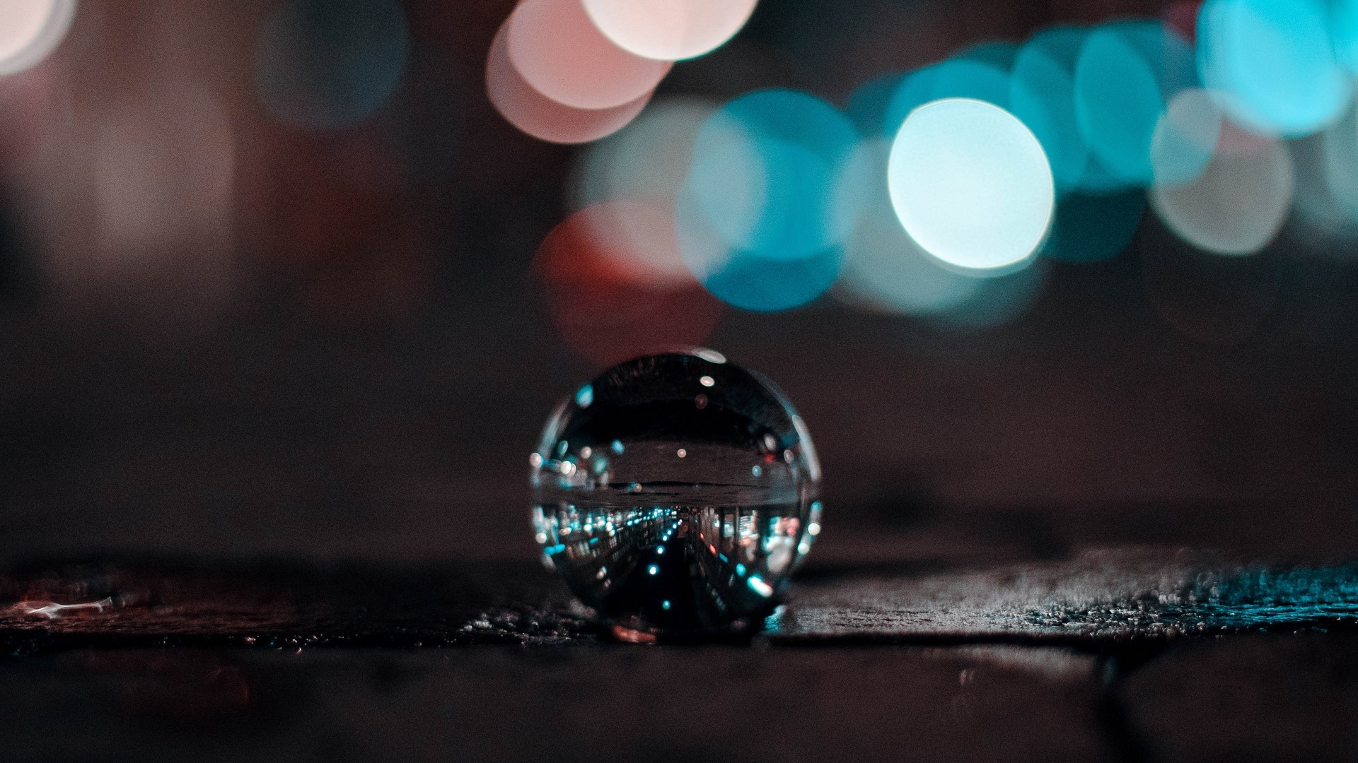 Glass ball reflecting city lights at night HD Wallpaper