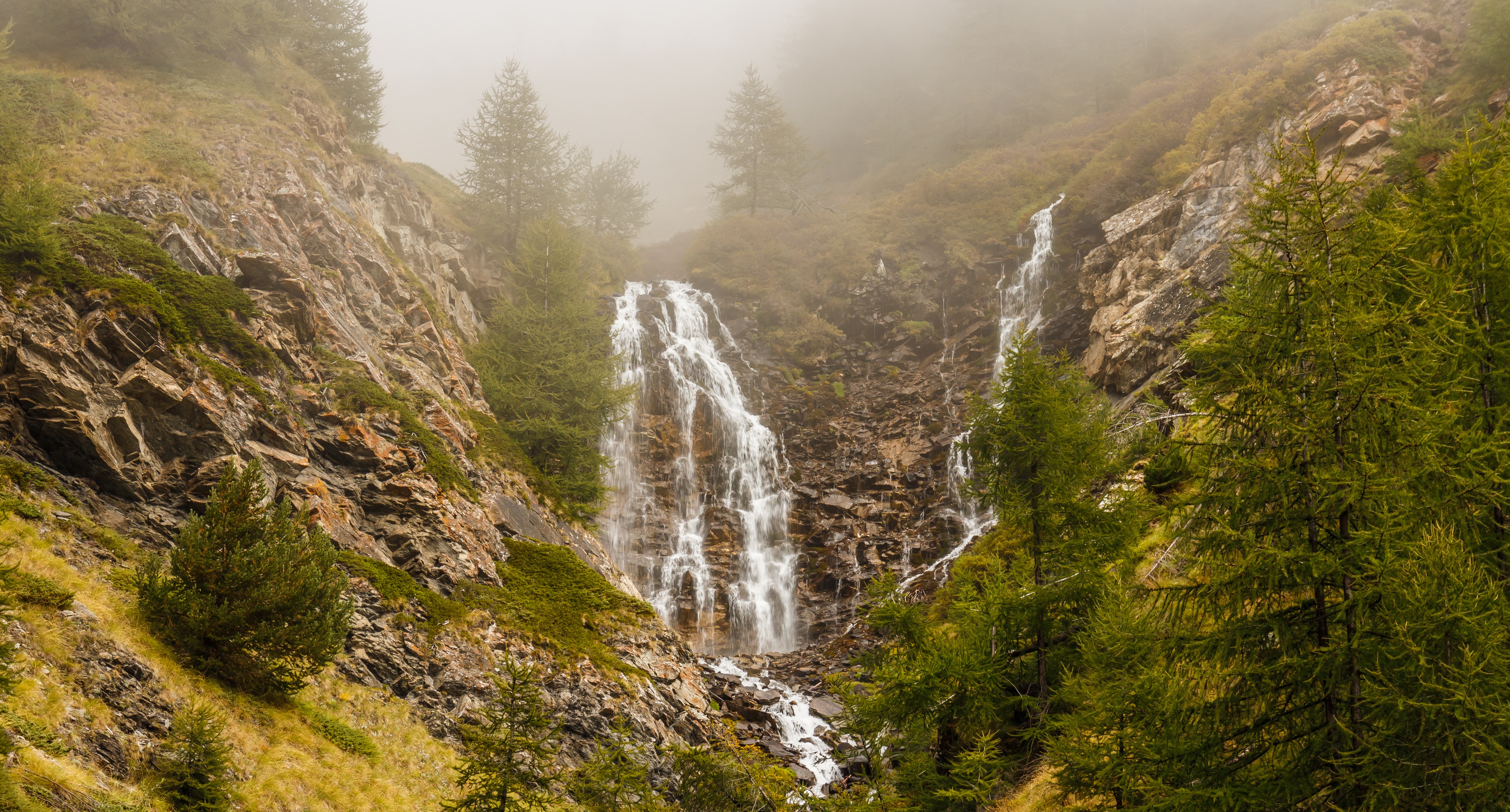 Waterfall in a misty mountain landscape with trees HD Wallpaper