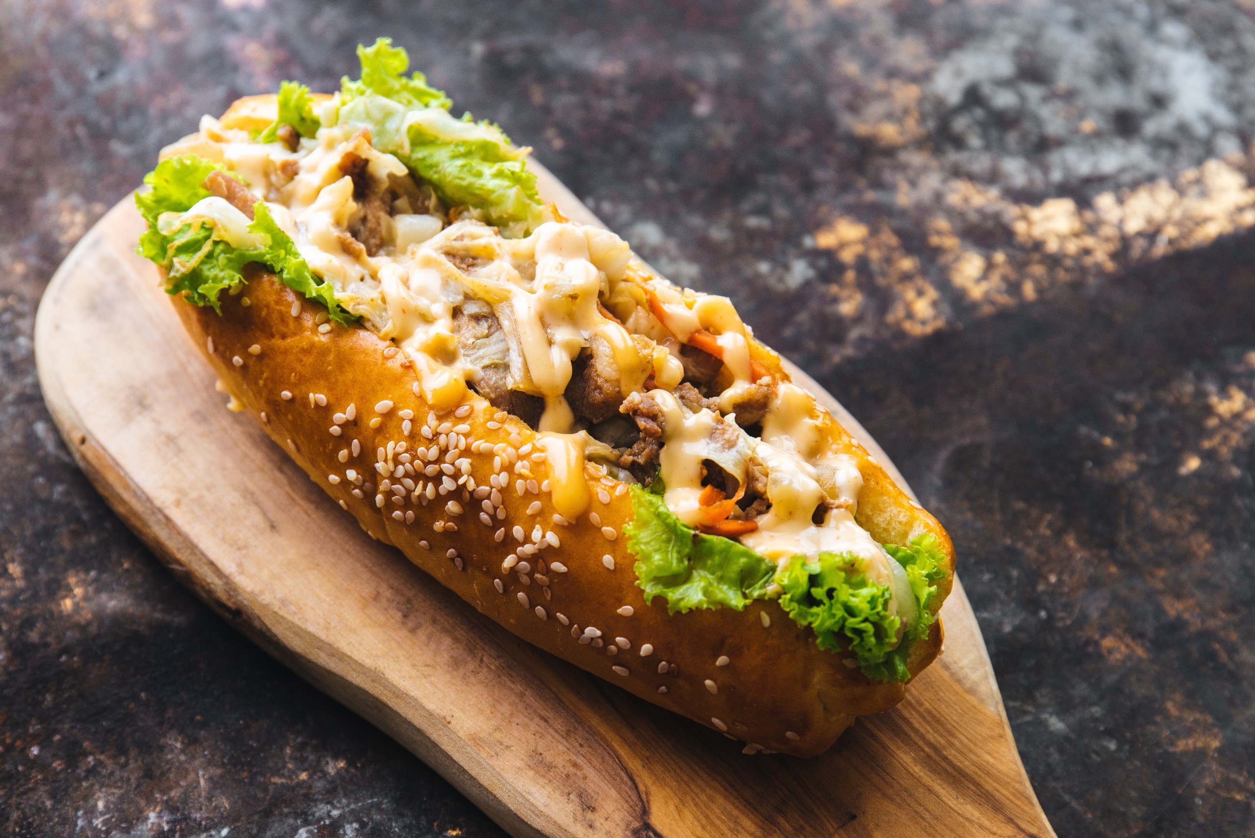 Hot dog with meat, lettuce, and cheese on a bun HD Wallpaper