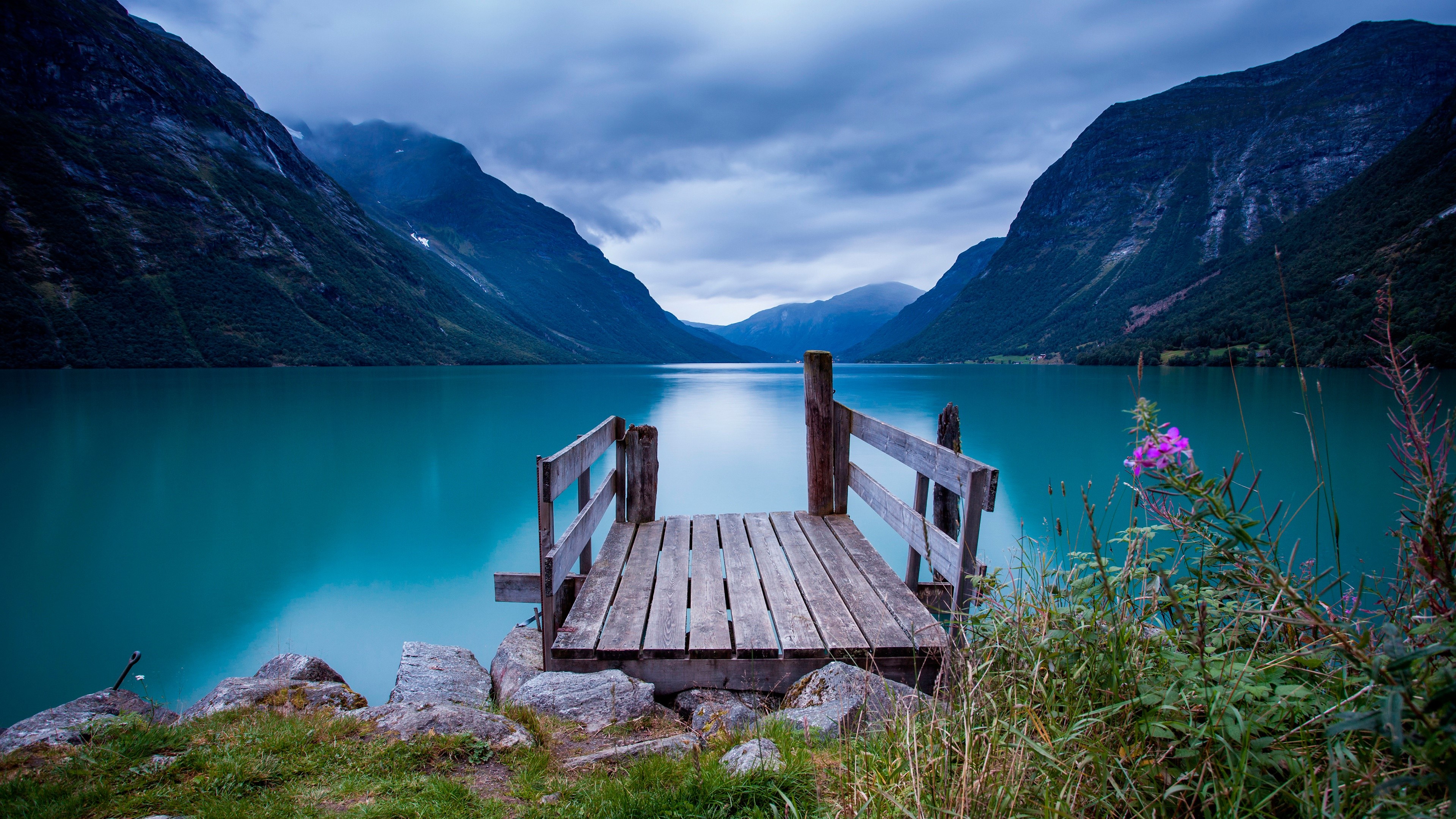 Wooden dock on a turquoise lake surrounded by mountains HD Wallpaper