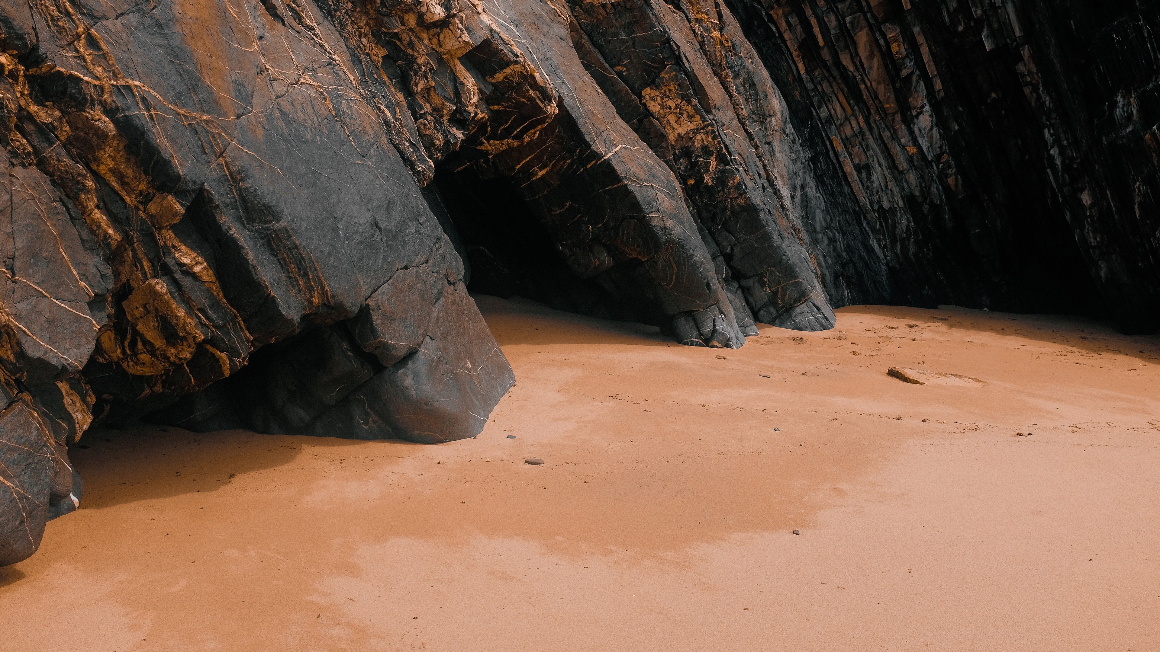 4K sand and rocks on a beach HD Wallpaper