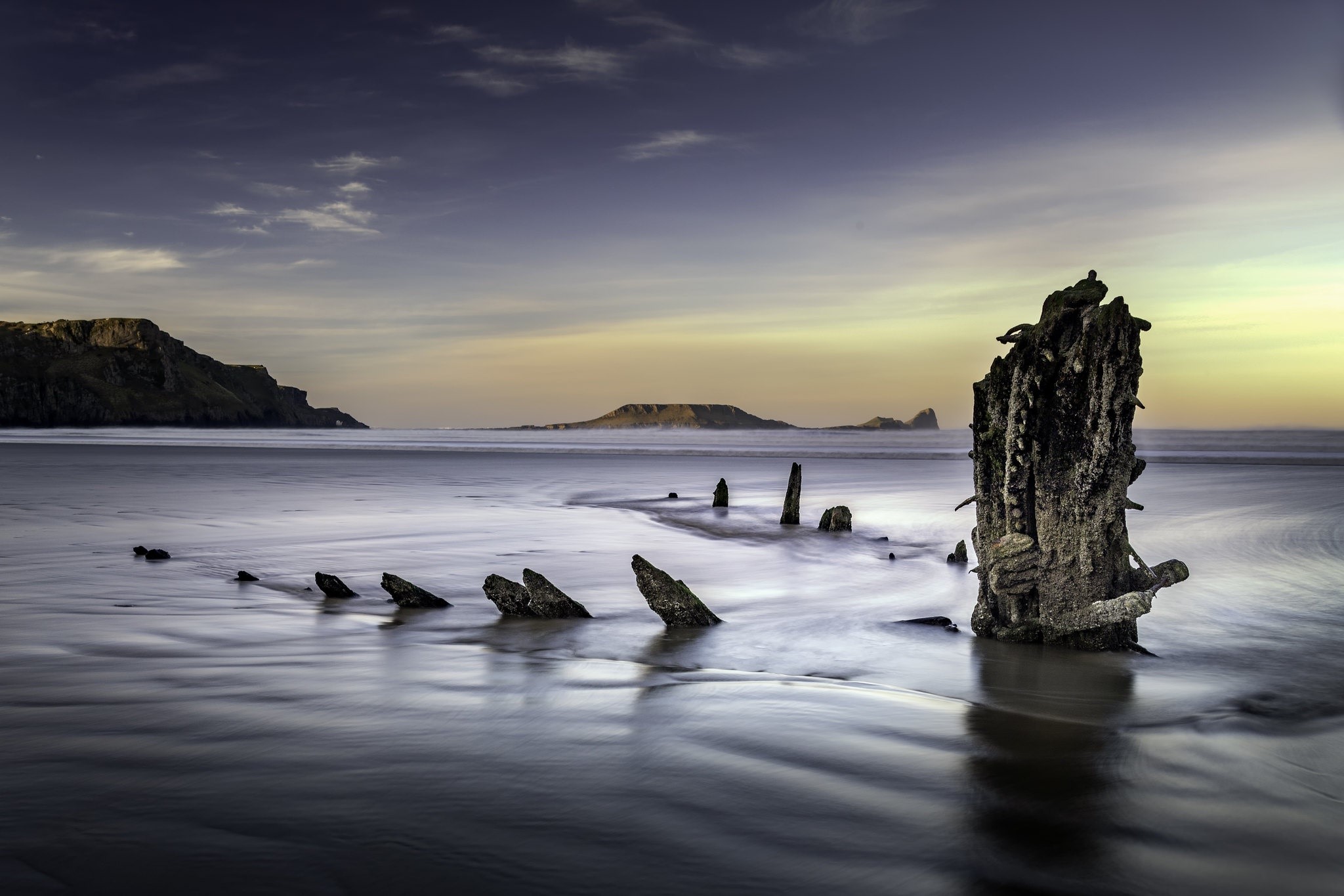 Shipwreck remains on a beach at sunset HD Wallpaper