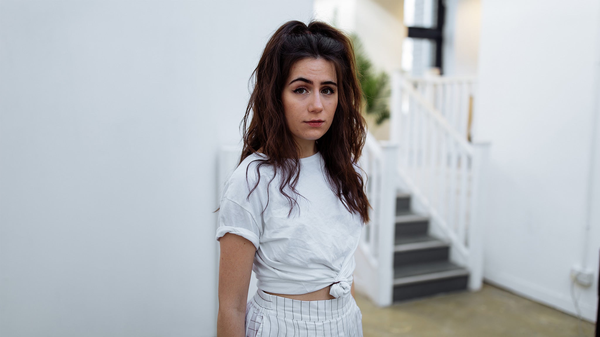 Dodie in a white t-shirt and striped pants HD Wallpaper
