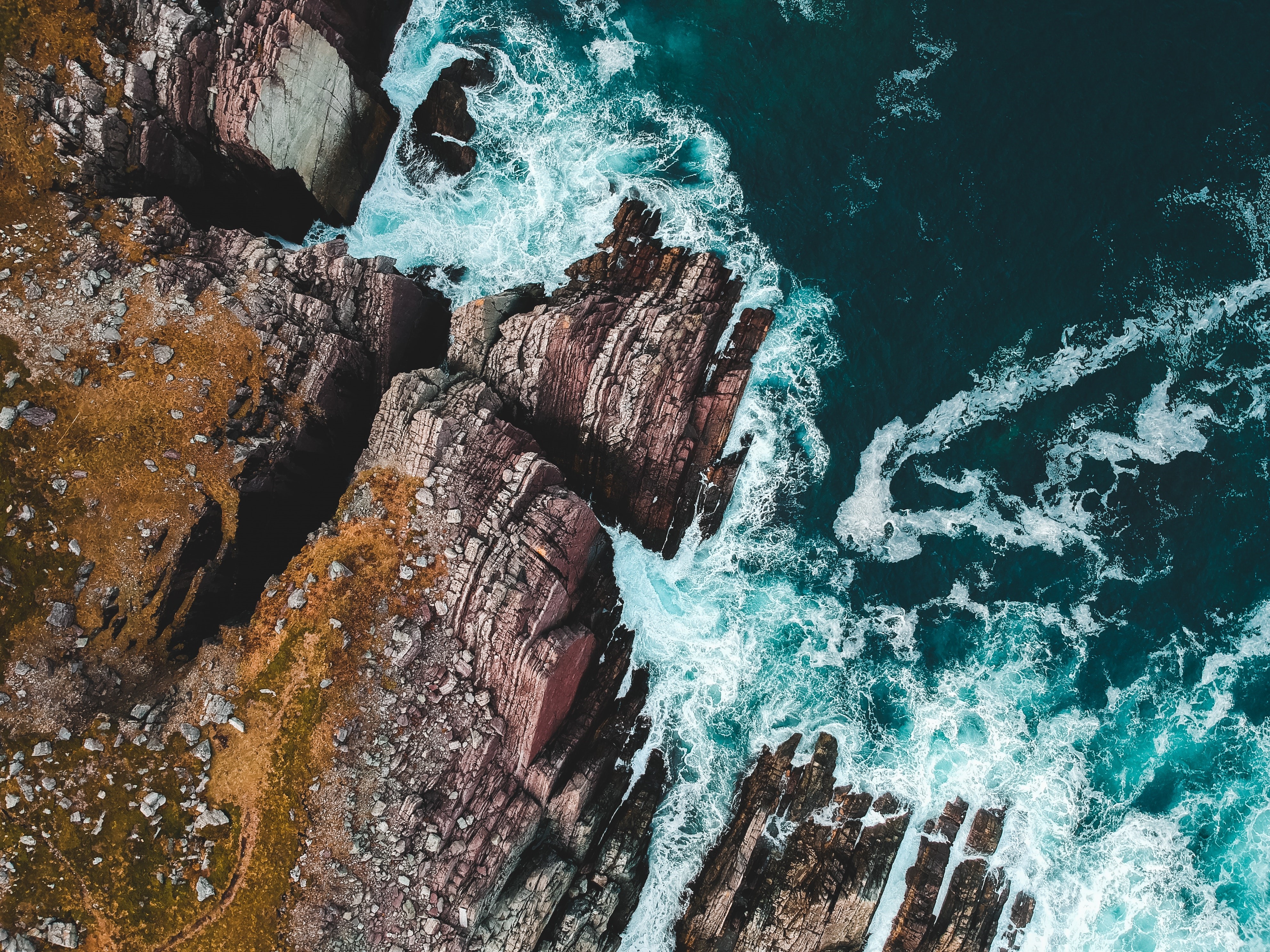 Aerial view of rocky coastline and blue sea HD Wallpaper