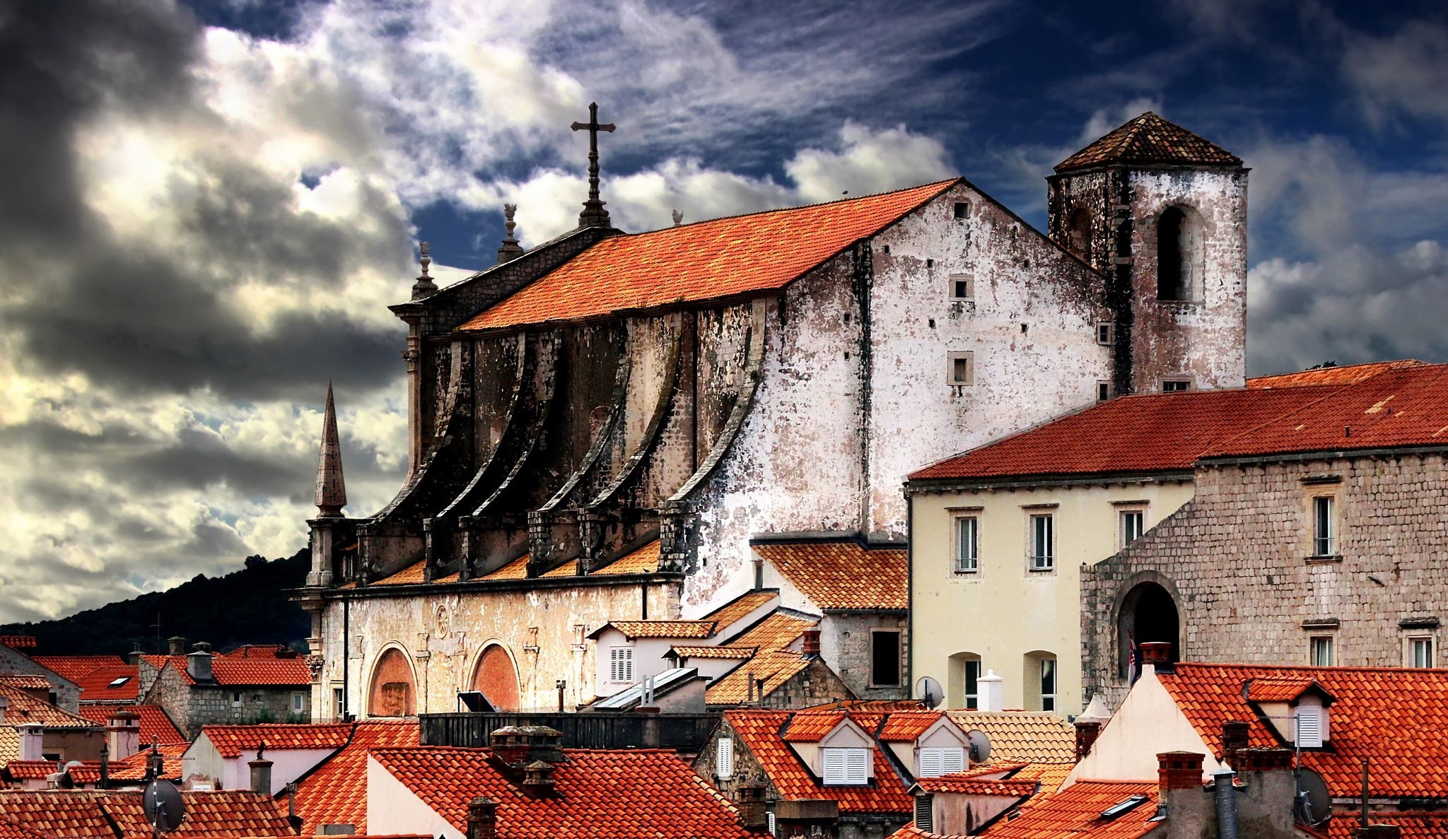 Old buildings with red roofs under a cloudy sky HD Wallpaper