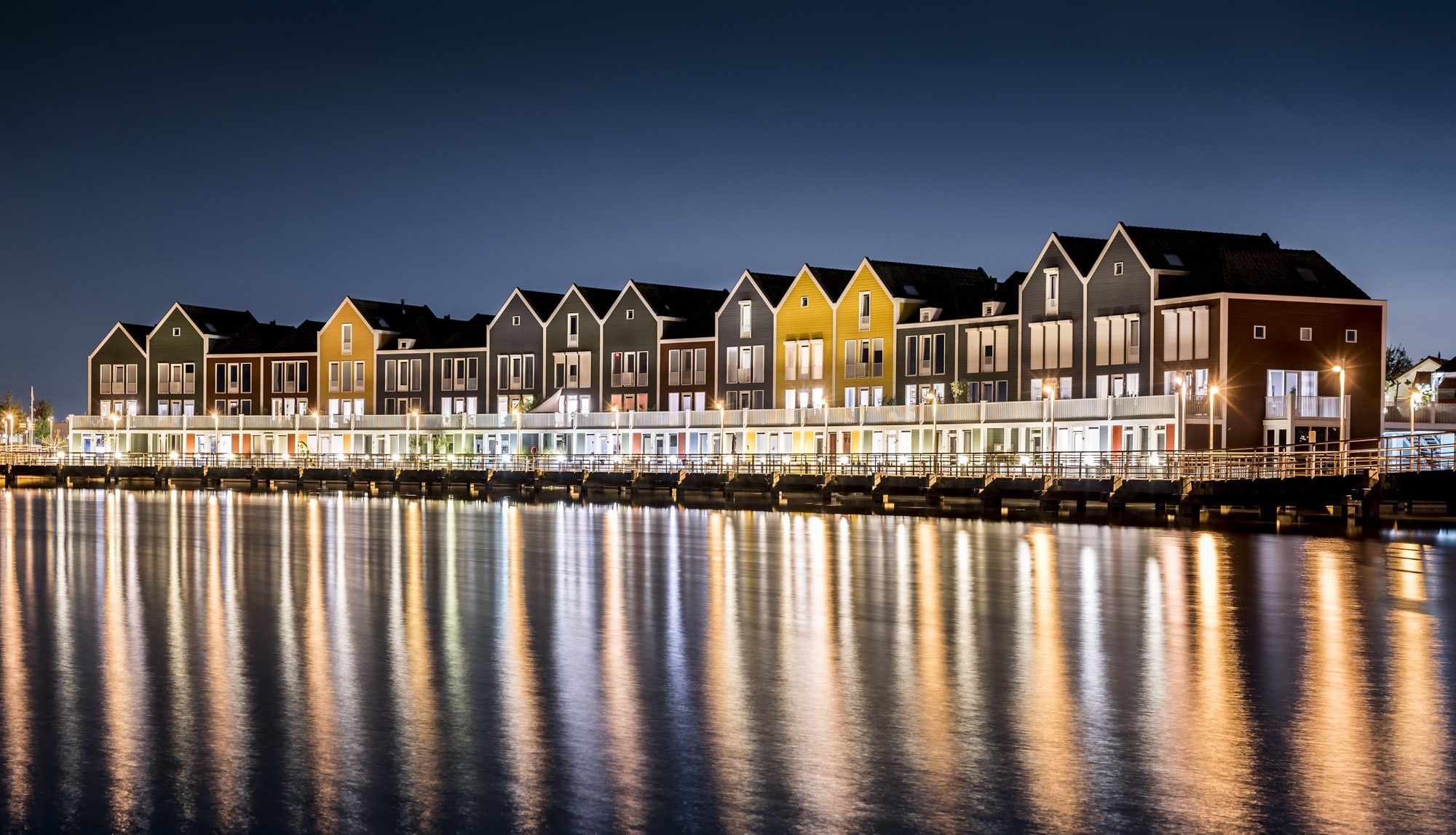 Colorful houses reflected in water at night HD Wallpaper