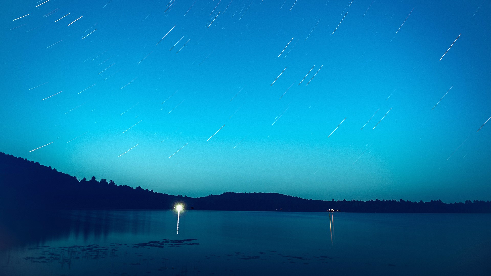 Star trails over a lake at night HD Wallpaper