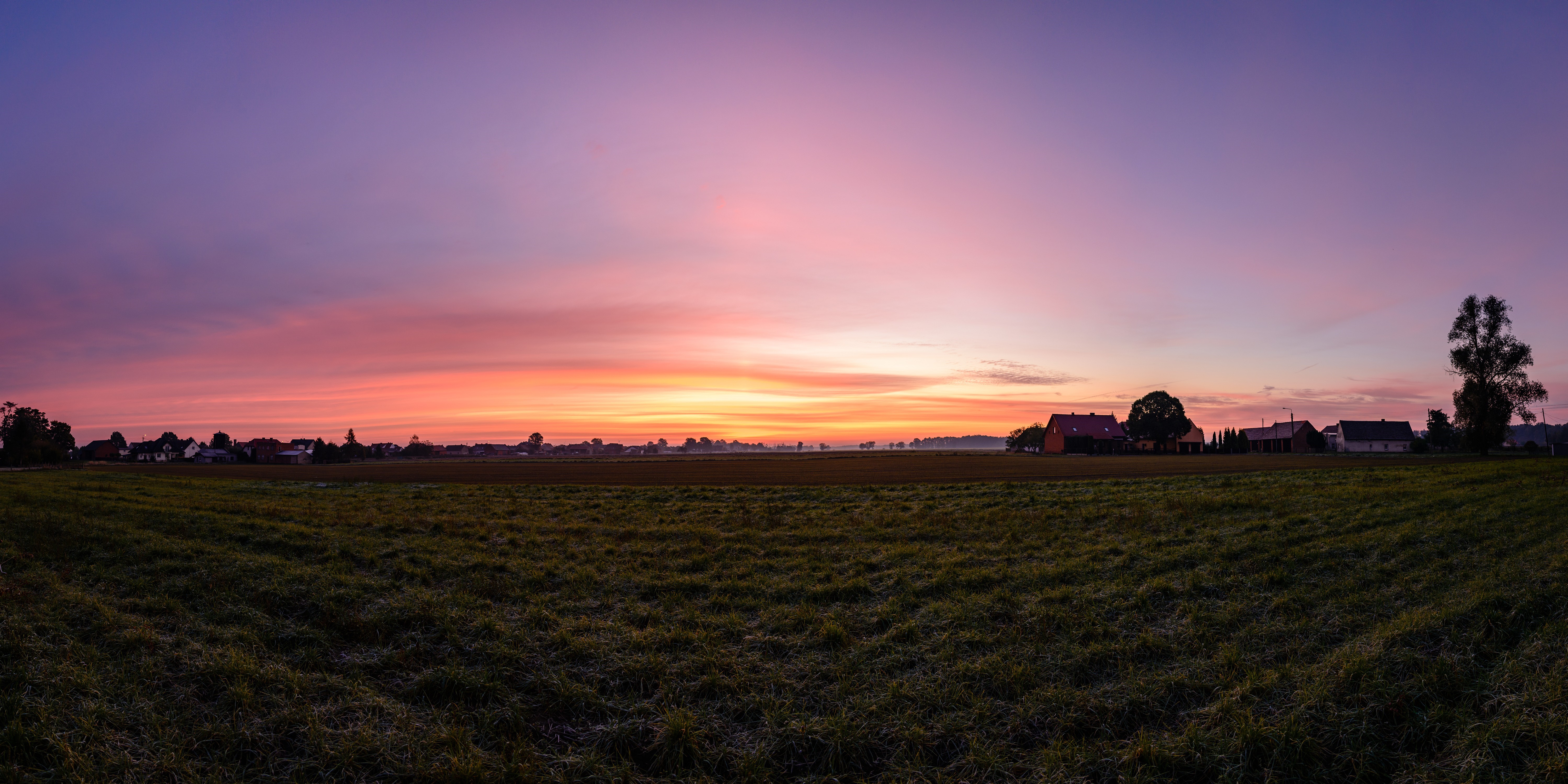 Panorama of a Polish village at sunrise with orange sky HD Wallpaper