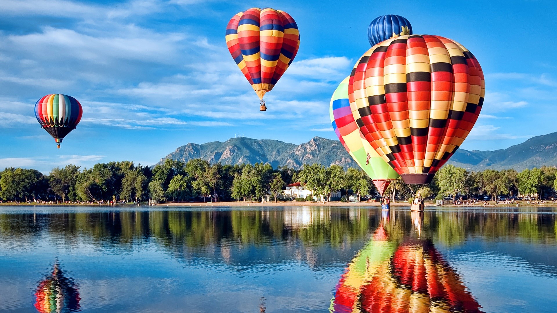 Hot air balloons over a lake with mountains HD Wallpaper