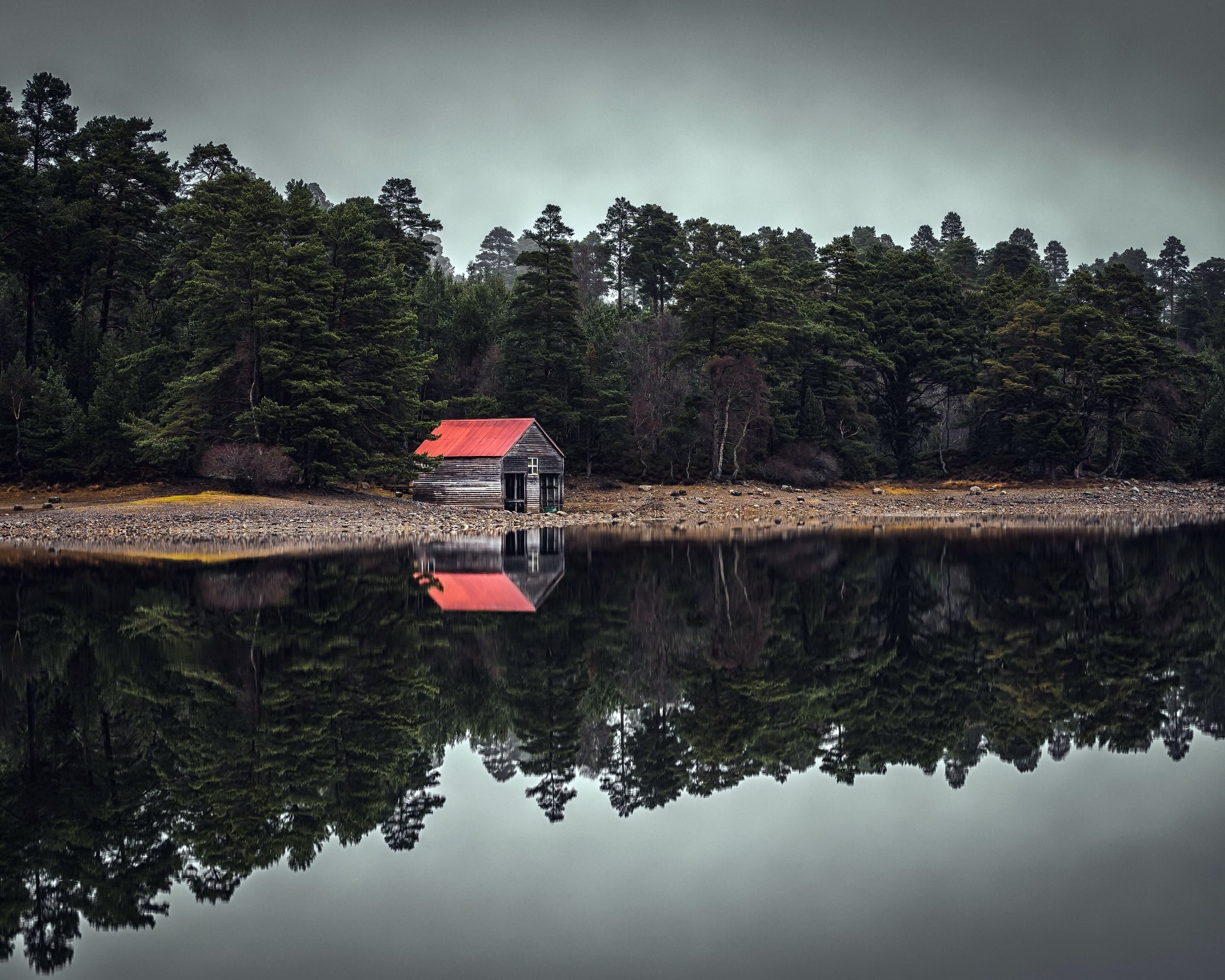 Wooden hut with red roof reflected in water HD Wallpaper