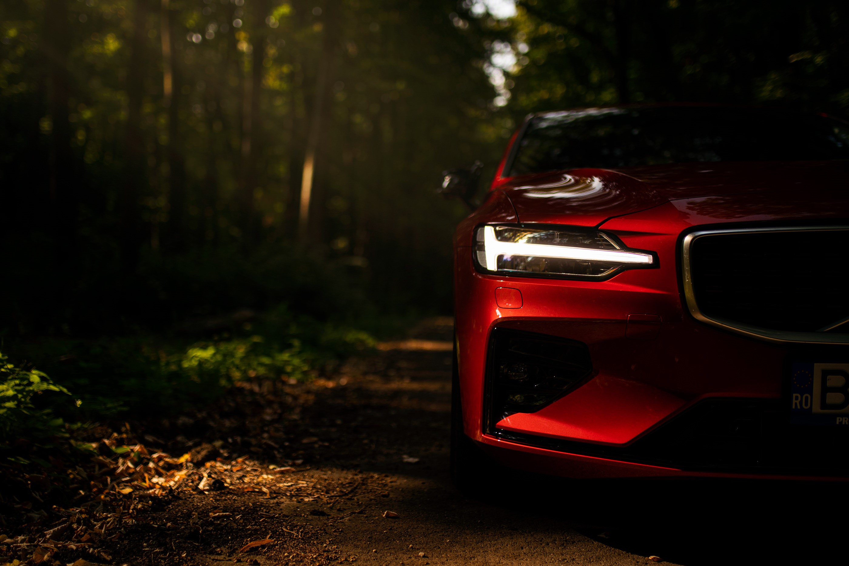 Red Volvo S60 with LED headlight in forest HD Wallpaper