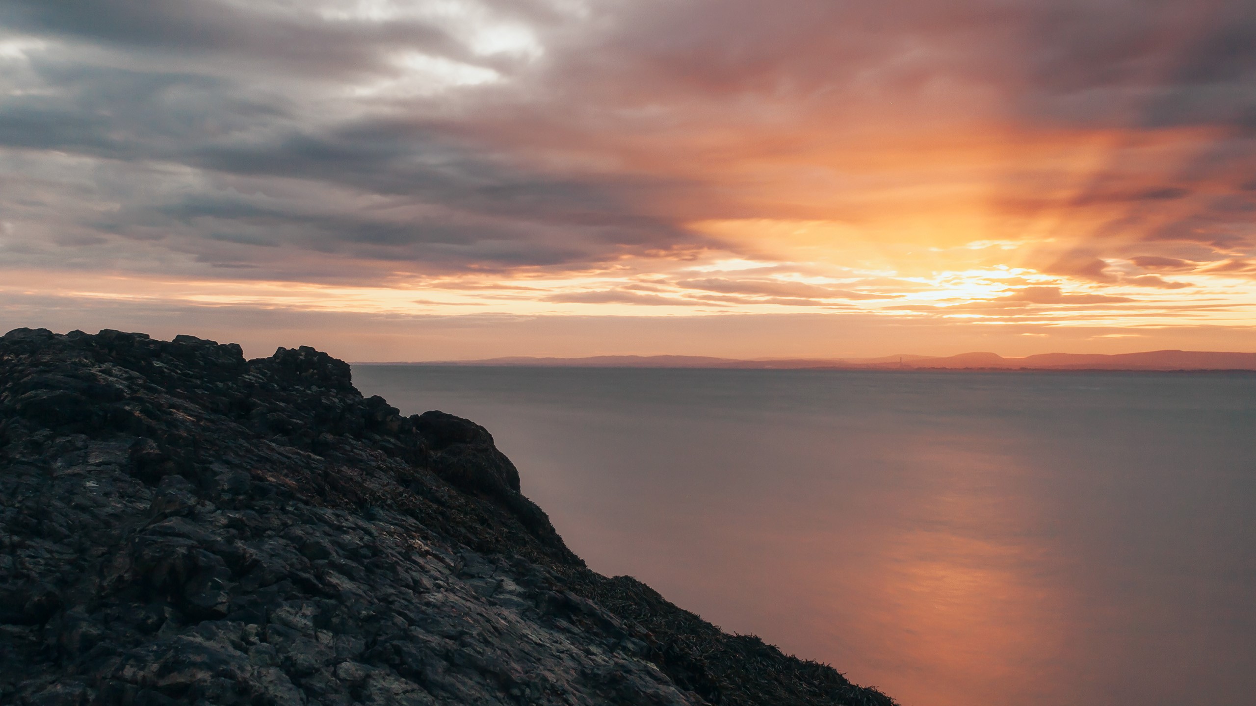 Rocky cliff overlooking the ocean at sunset HD Wallpaper