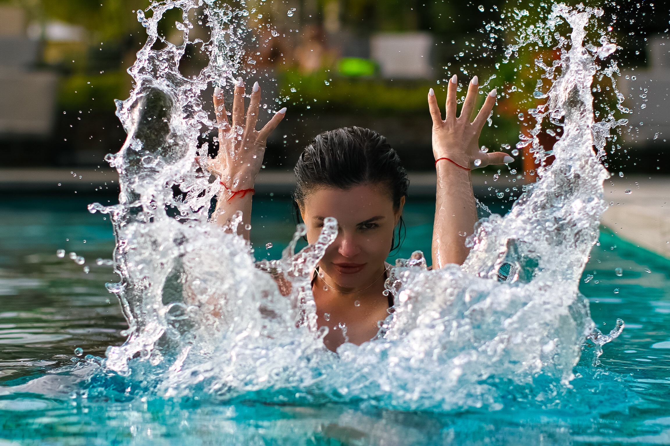 Woman splashing water in a pool HD Wallpaper
