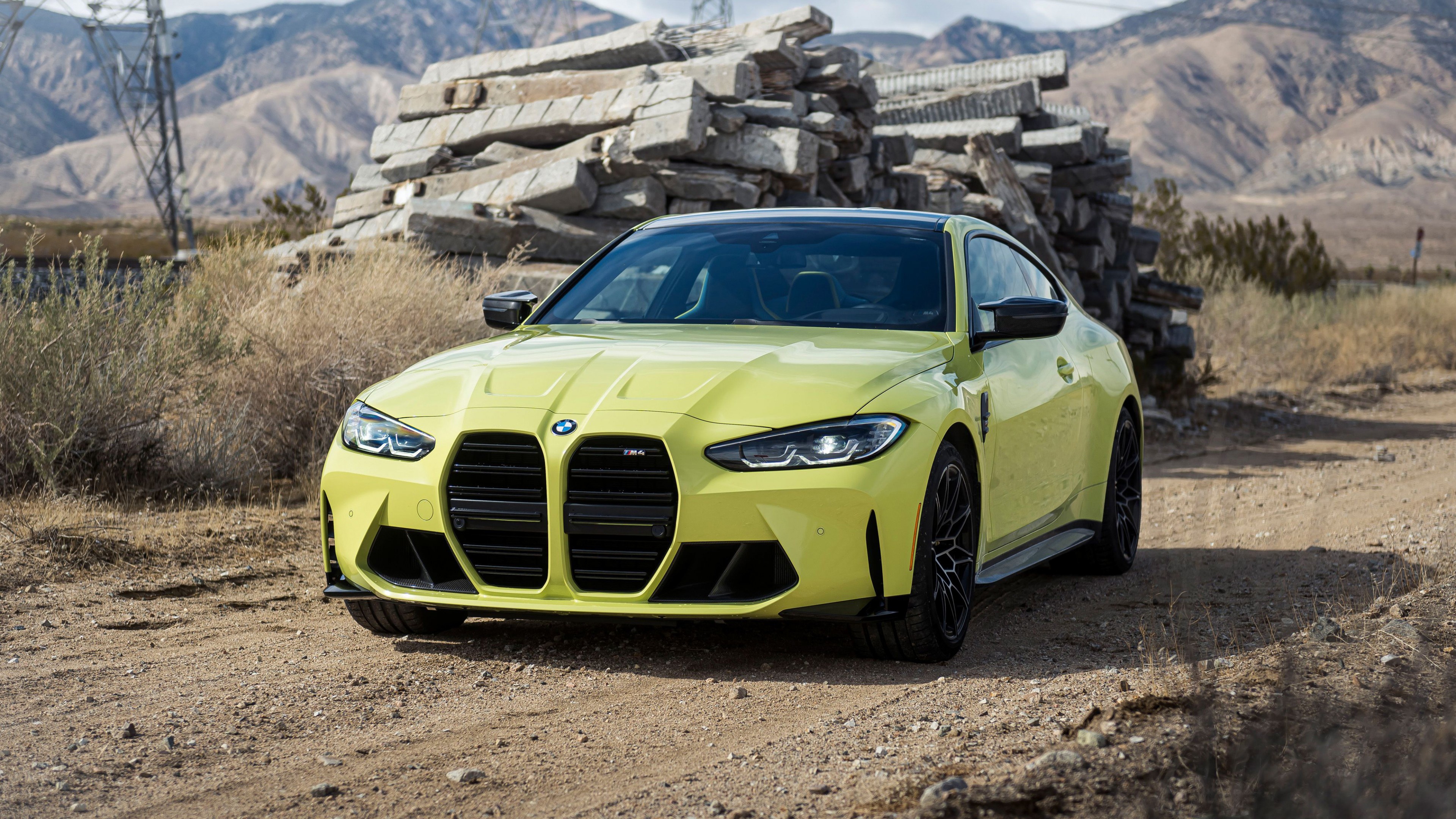 Yellow BMW M4 parked on a dirt road HD Wallpaper