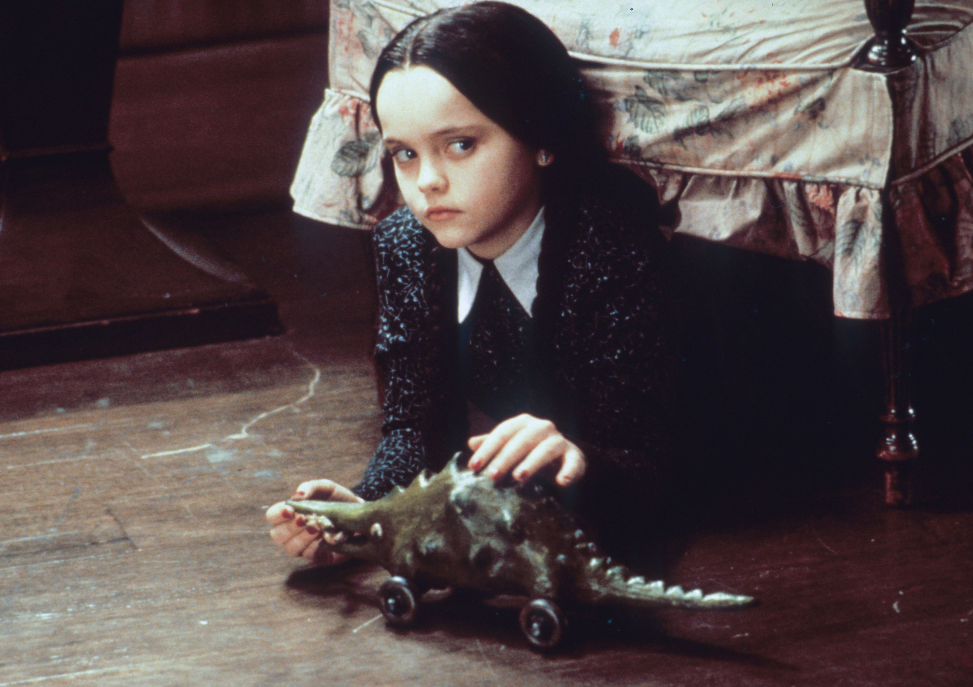 Wednesday Addams with a toy dinosaur HD Wallpaper