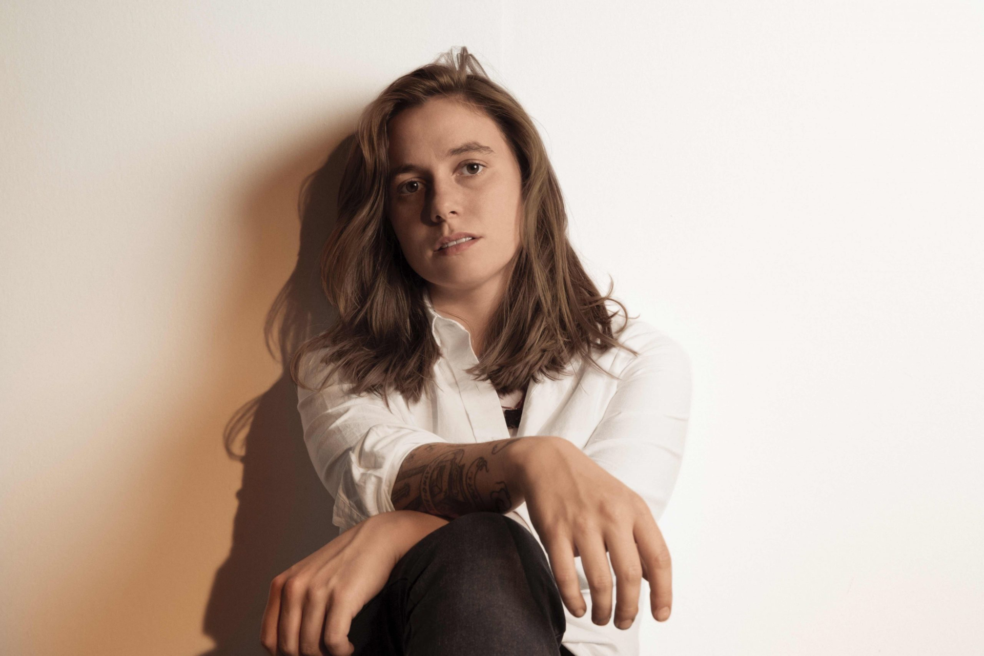 Julien Baker sits against a wall HD Wallpaper