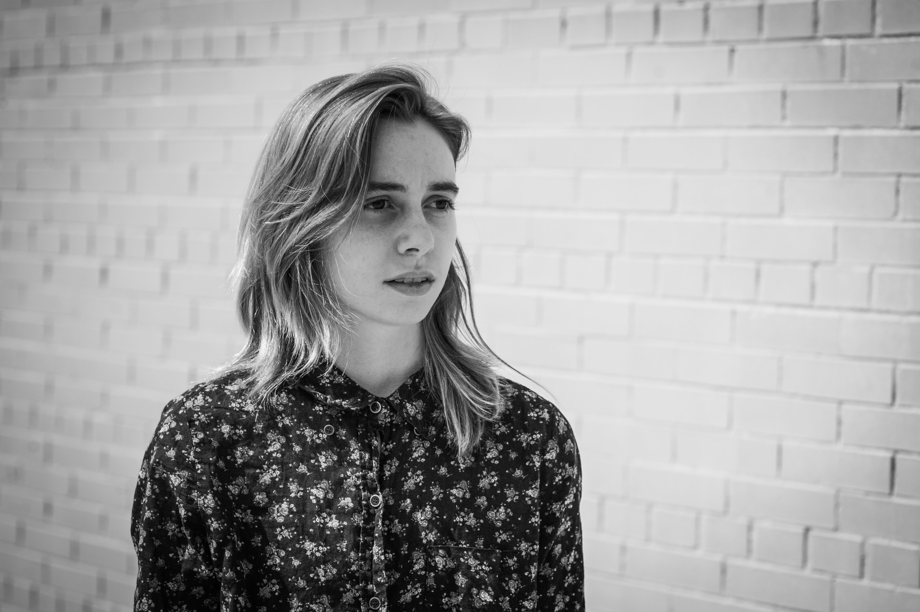 Julien Baker in front of a brick wall HD Wallpaper