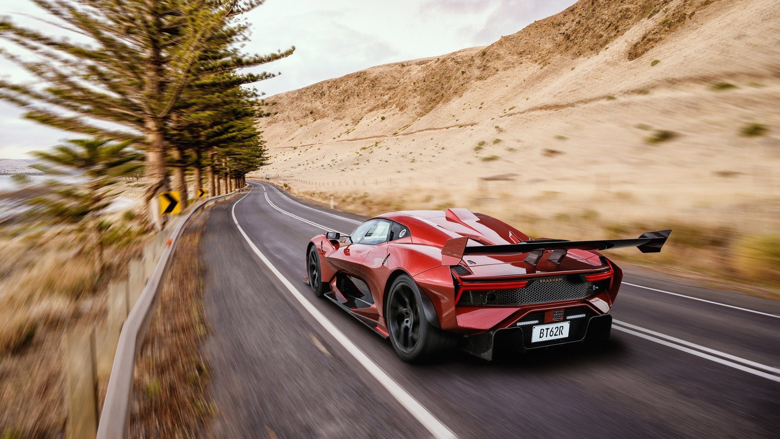 Red Brabham BT62R driving on a winding road HD Wallpaper