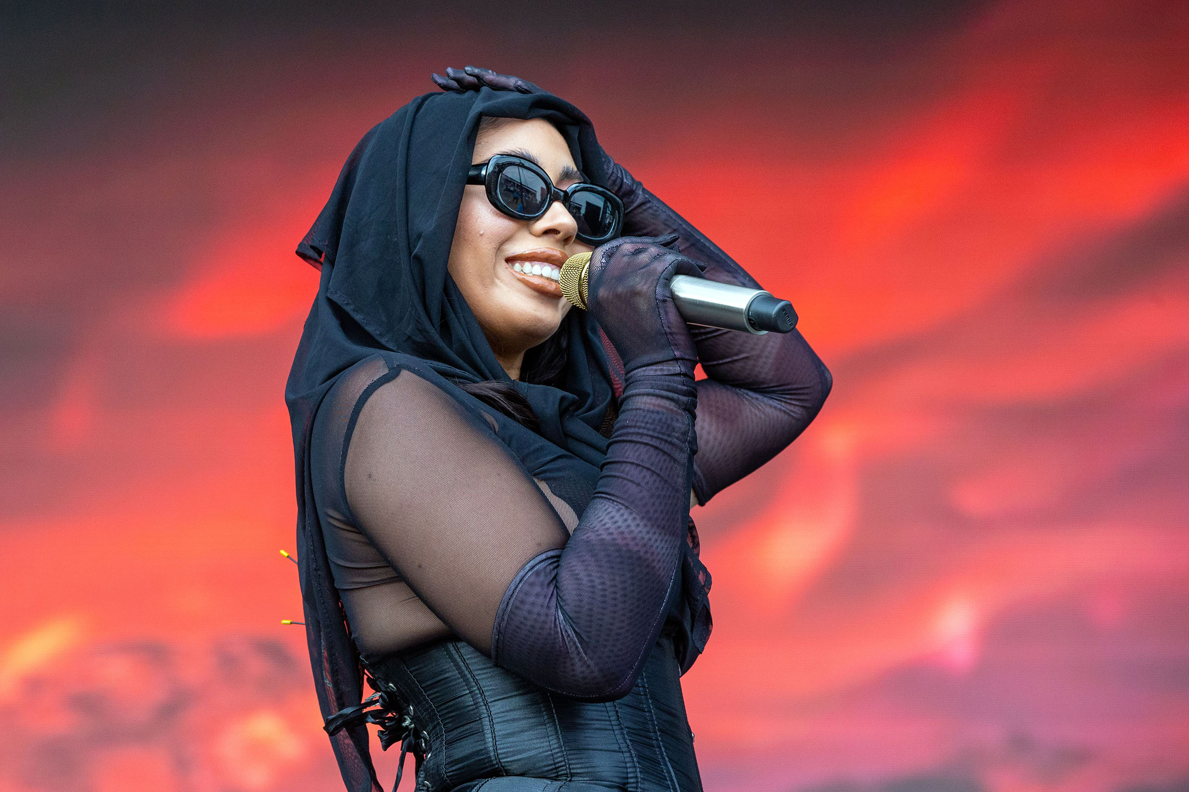 Kali Uchis performs on stage with a microphone HD Wallpaper
