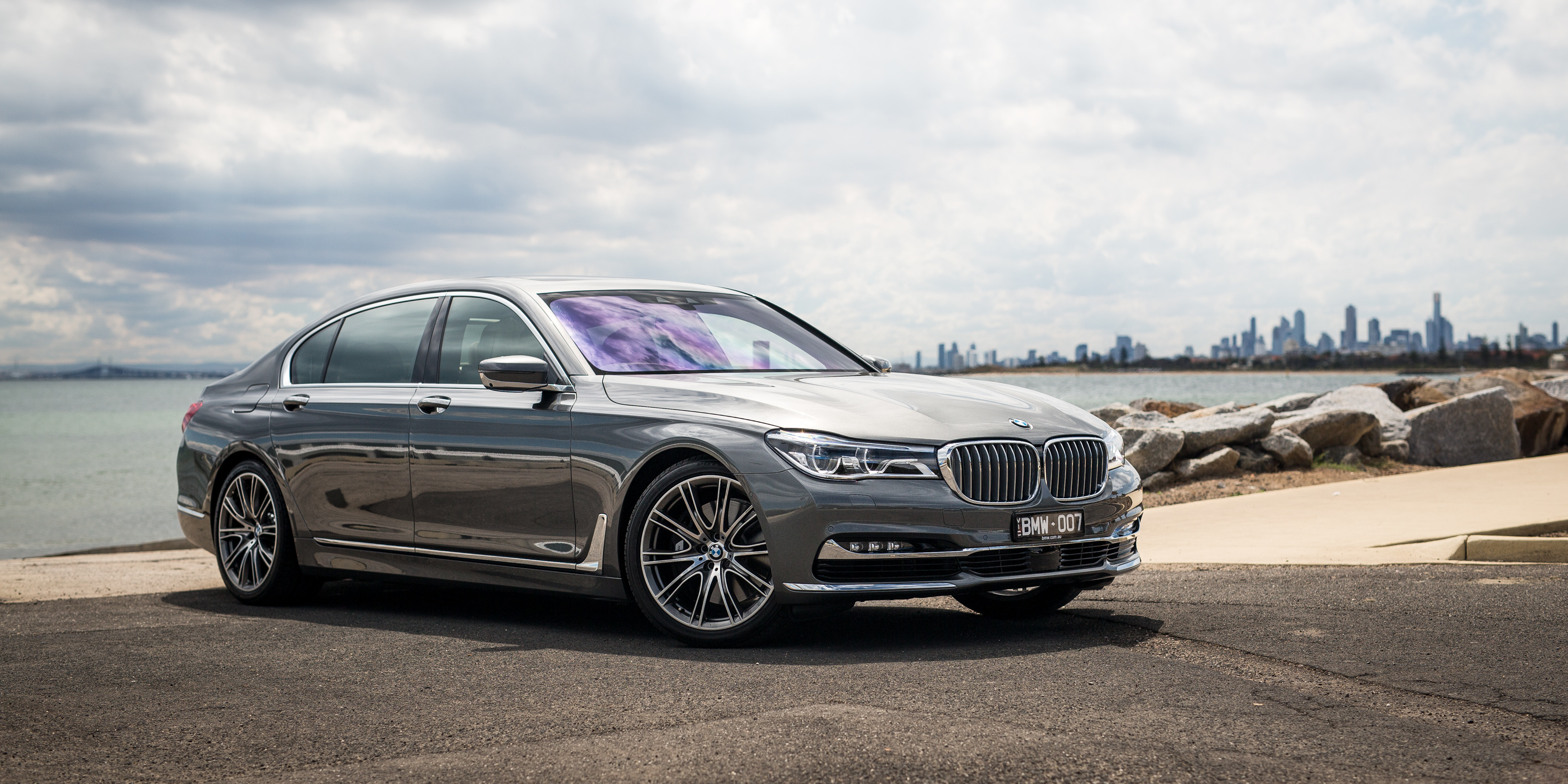 Silver BMW 7 Series parked by the water HD Wallpaper