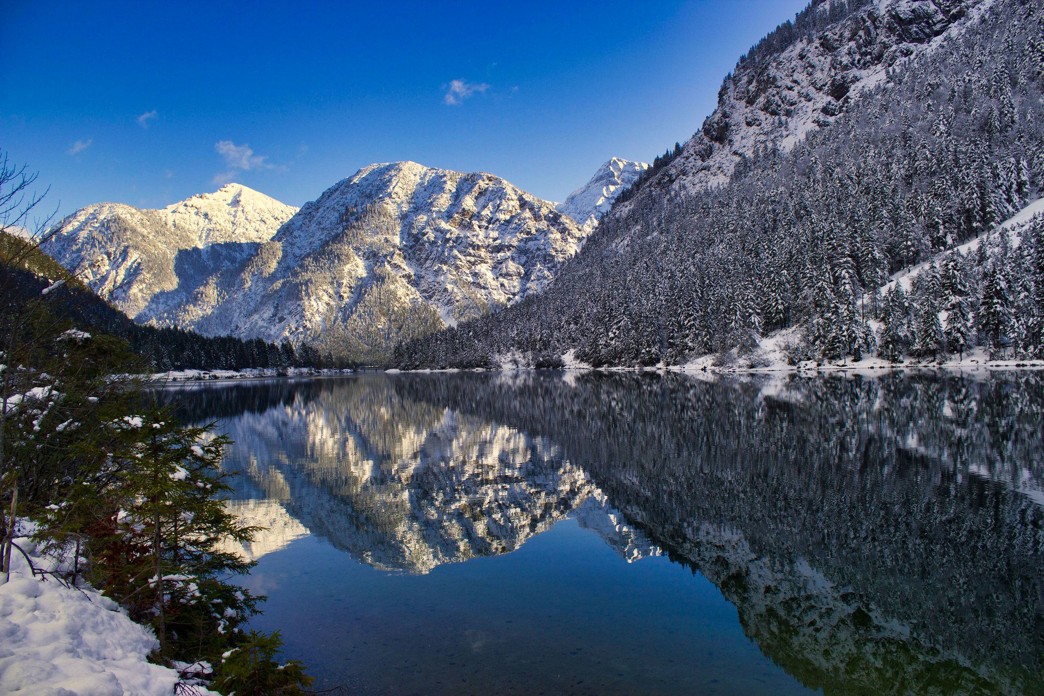 Snow-covered mountains reflected in a calm lake HD Wallpaper
