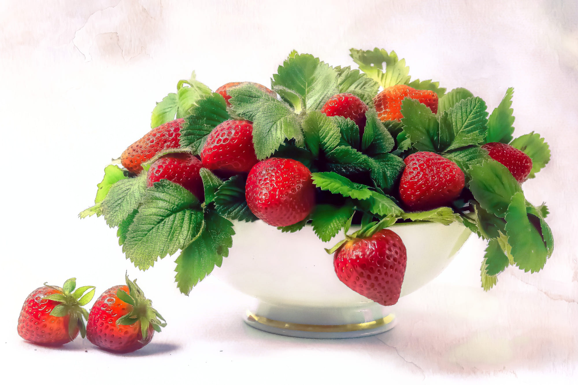 Strawberries in a white bowl with green leaves HD Wallpaper