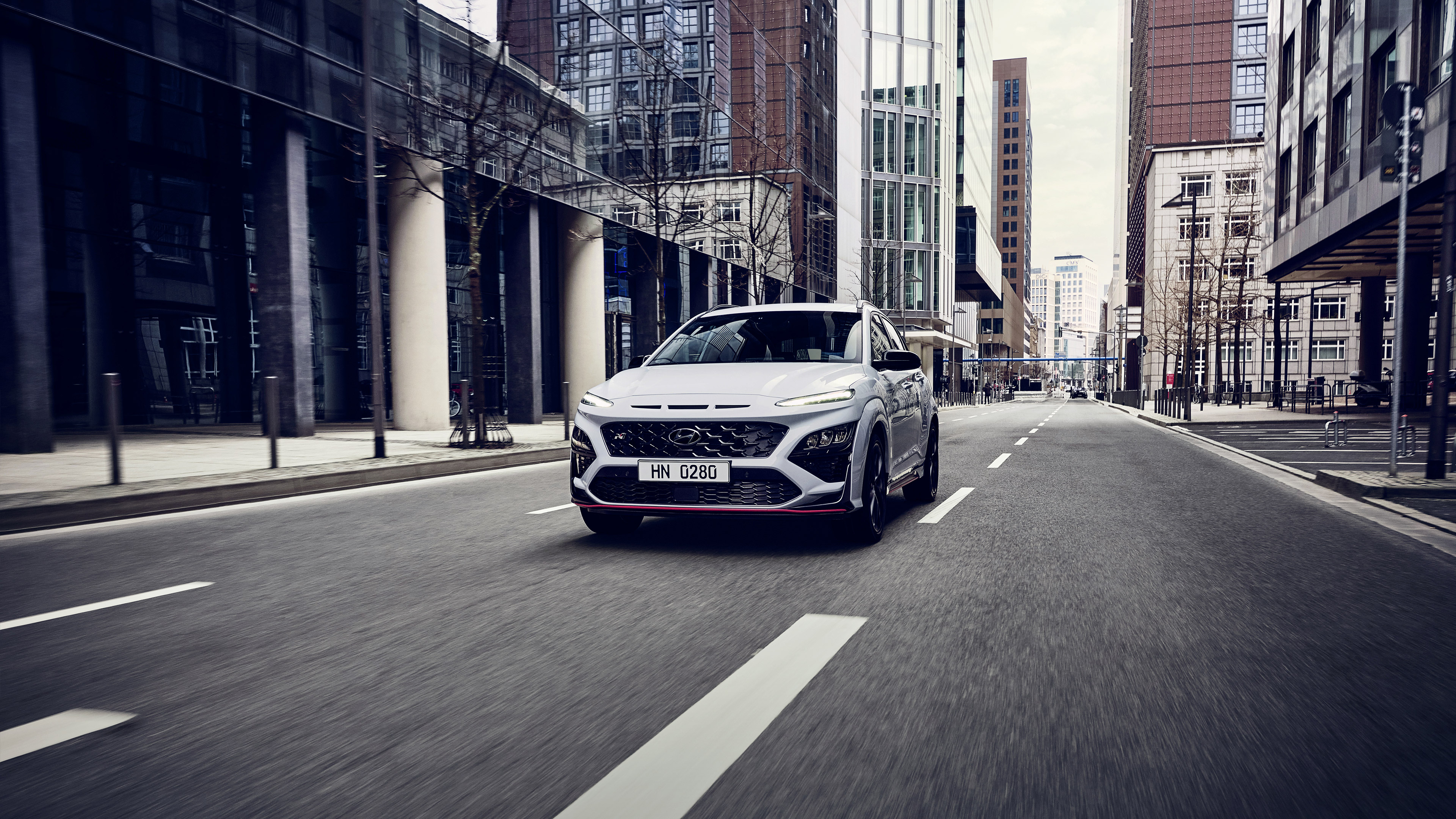 White Hyundai Kona N driving on a city street HD Wallpaper