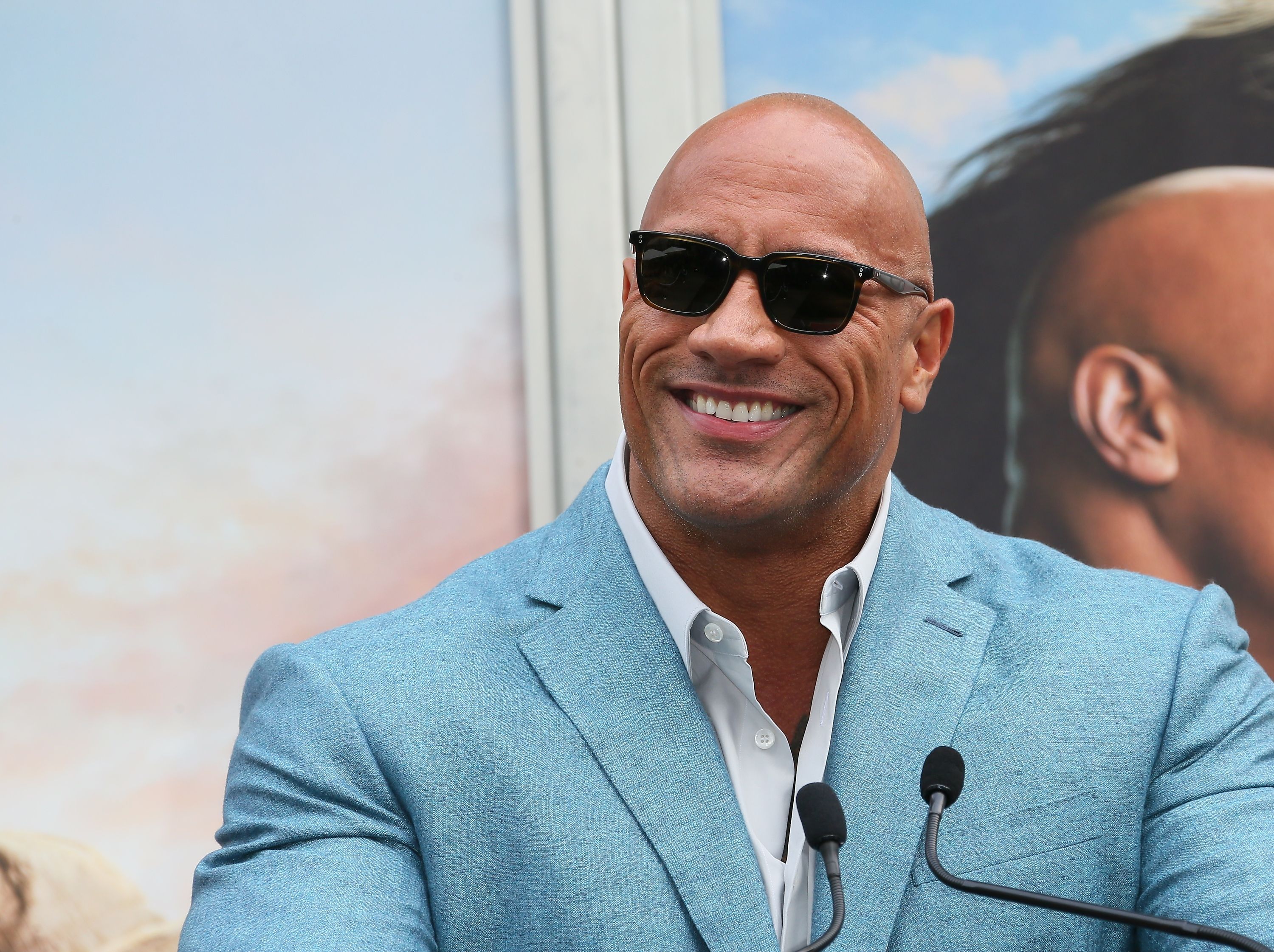 Dwayne Johnson smiles at an event HD Wallpaper
