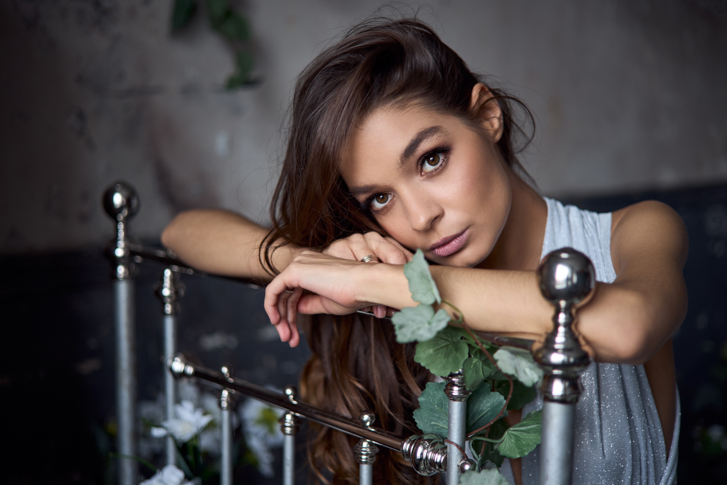 Woman with brunette hair leaning on a bed frame HD Wallpaper
