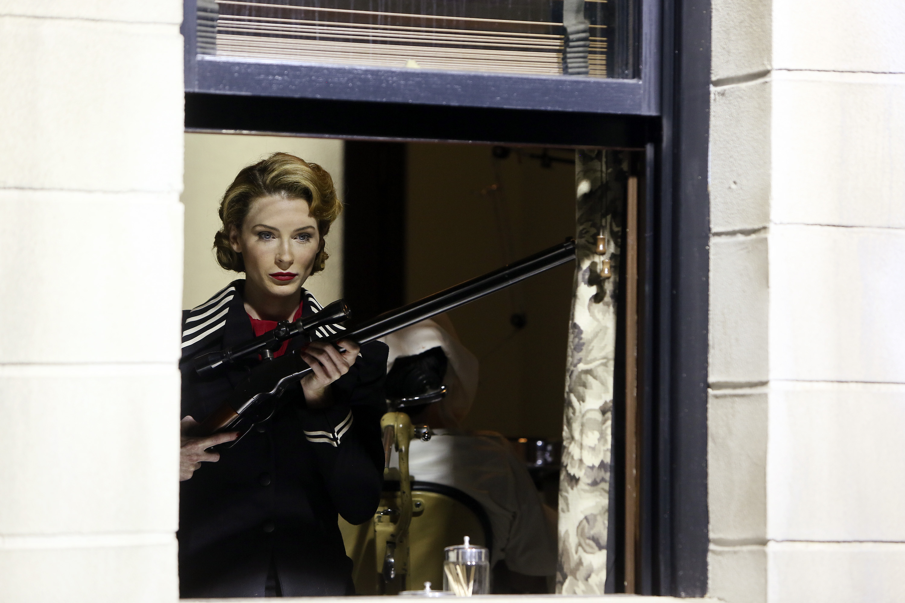 Woman with sniper rifle looking out window HD Wallpaper