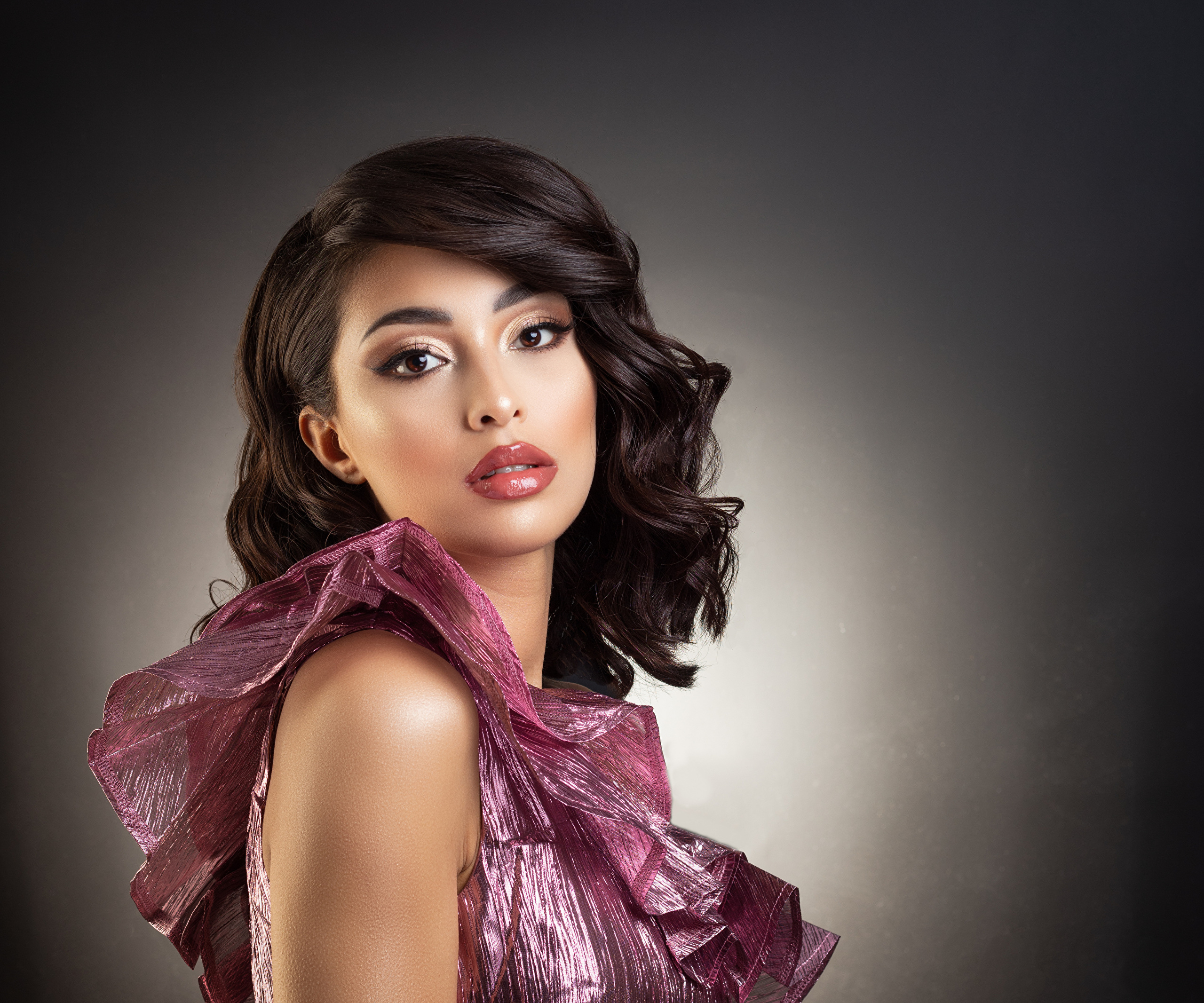 Woman with dark wavy hair and pink dress HD Wallpaper
