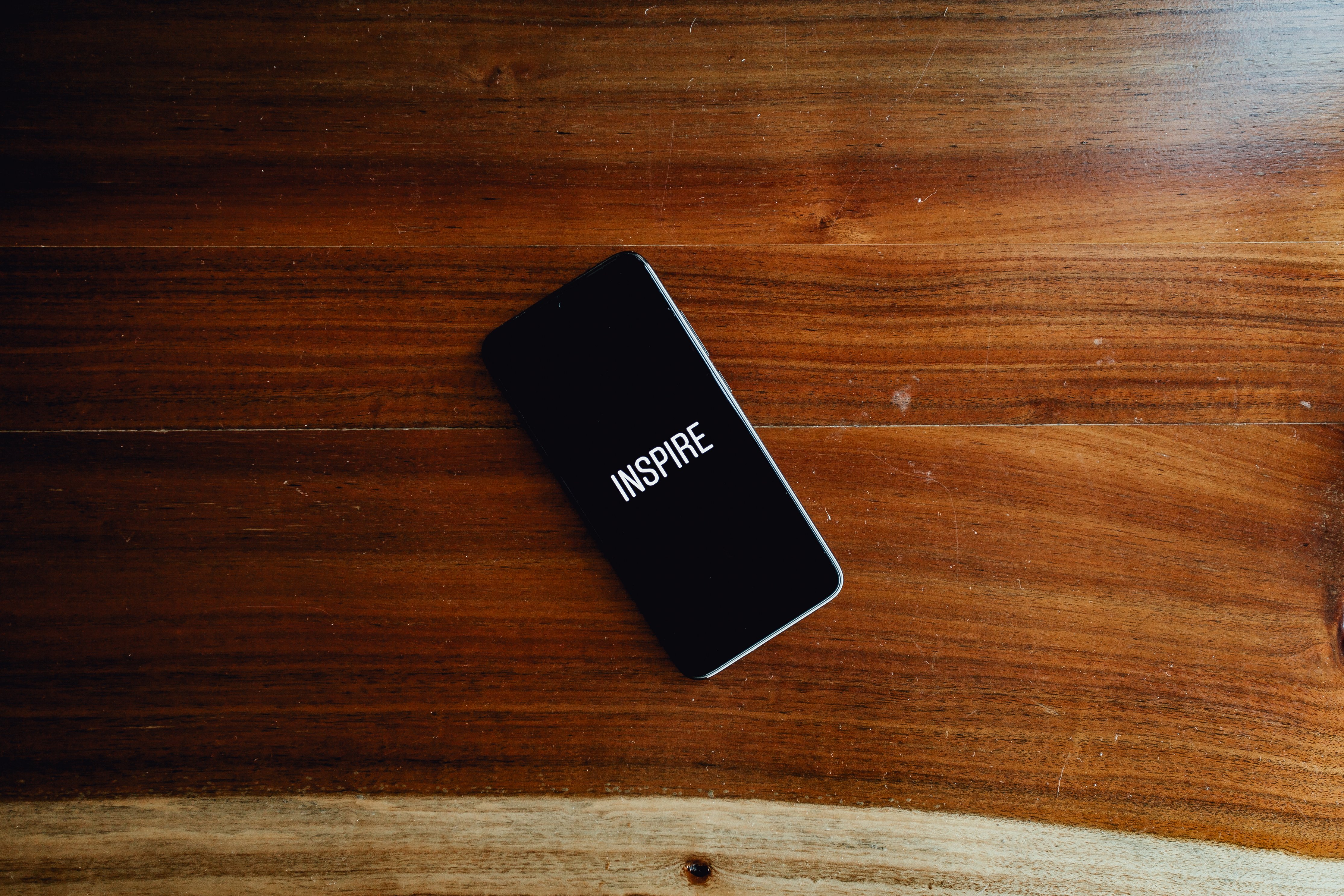 Smartphone with the word "Inspire" on screen HD Wallpaper