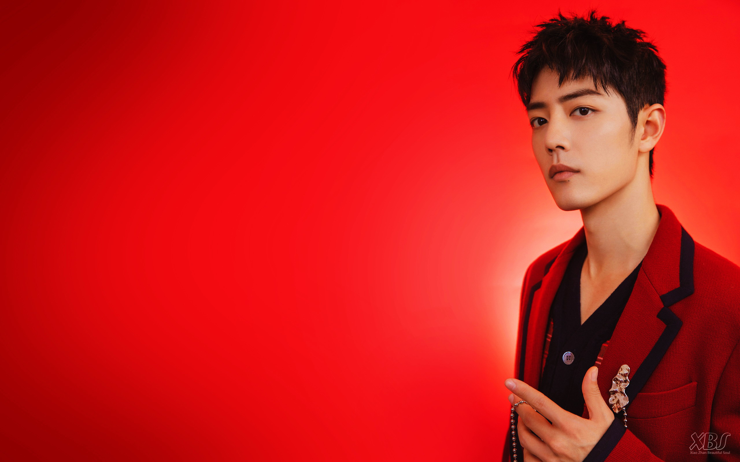 Xiao Zhan in a red jacket against a red background HD Wallpaper
