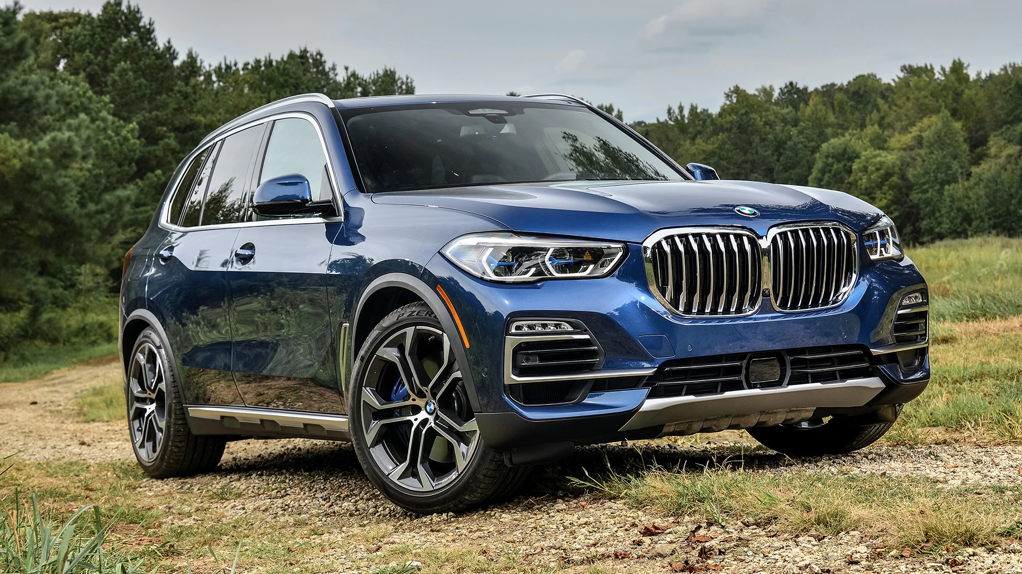Blue BMW X5 SUV parked on a dirt road HD Wallpaper