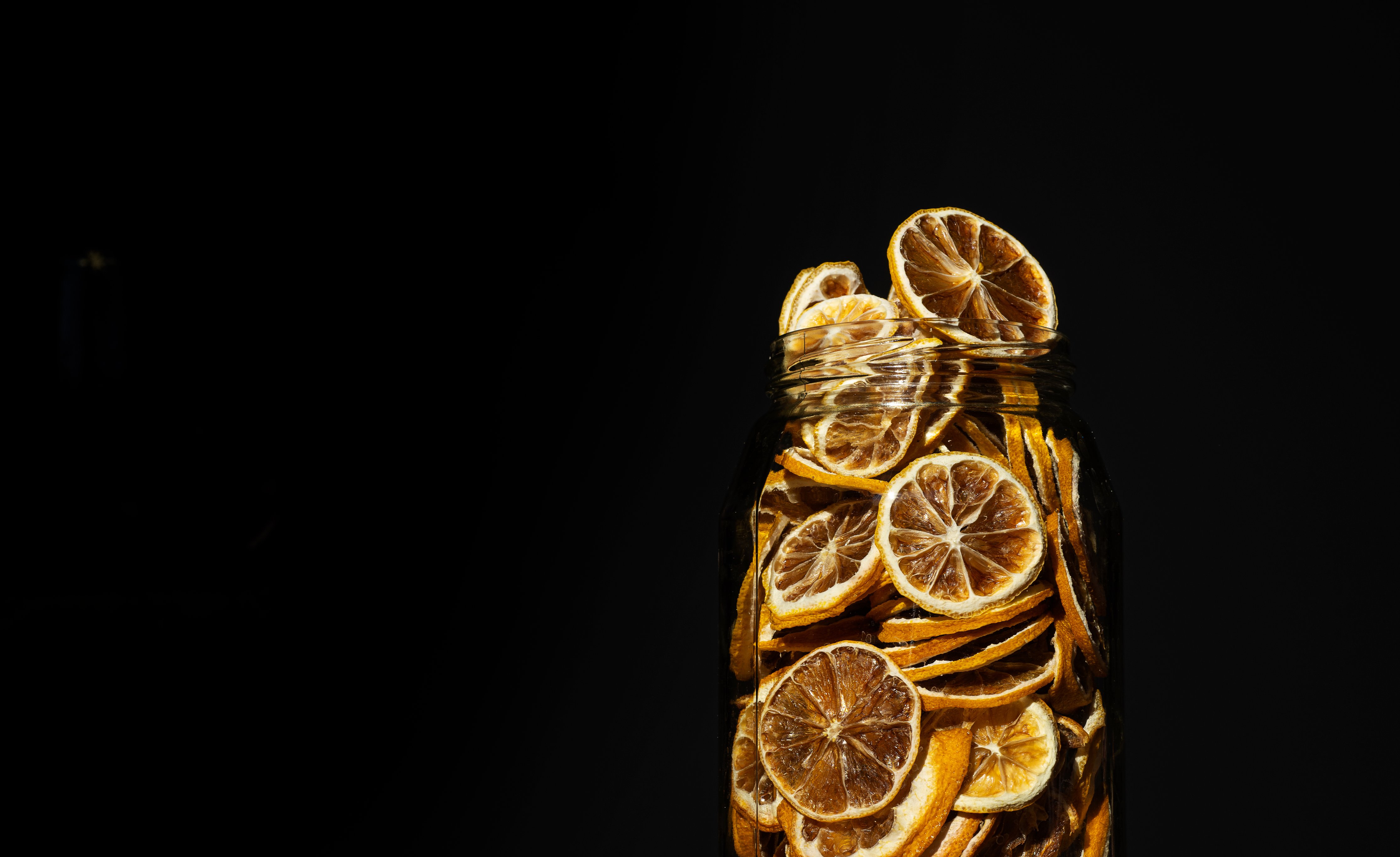 Glass jar filled with dried lemon slices HD Wallpaper