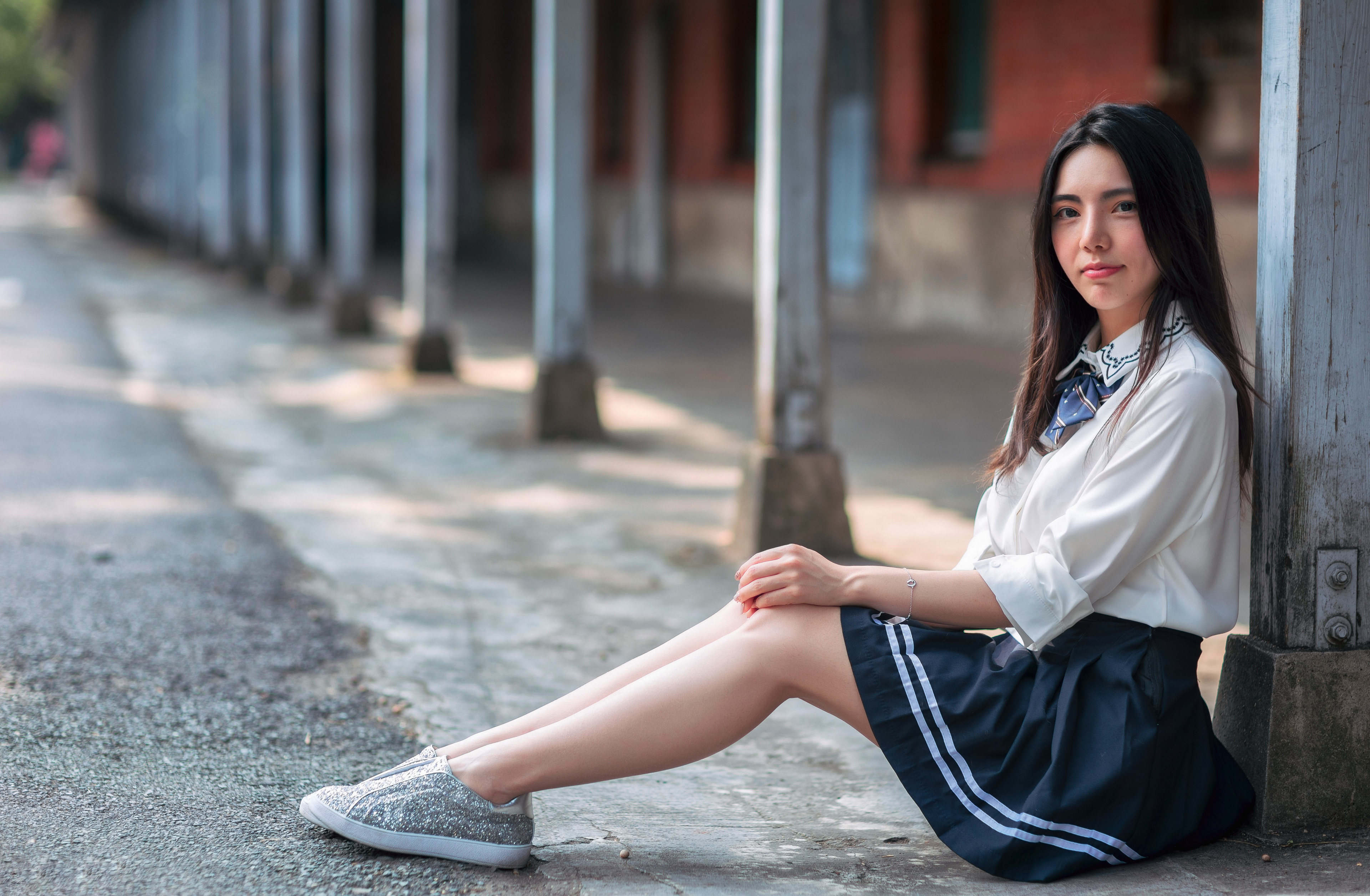Young Asian Woman in Skirt Sitting Outdoors 4K HD Wallpaper