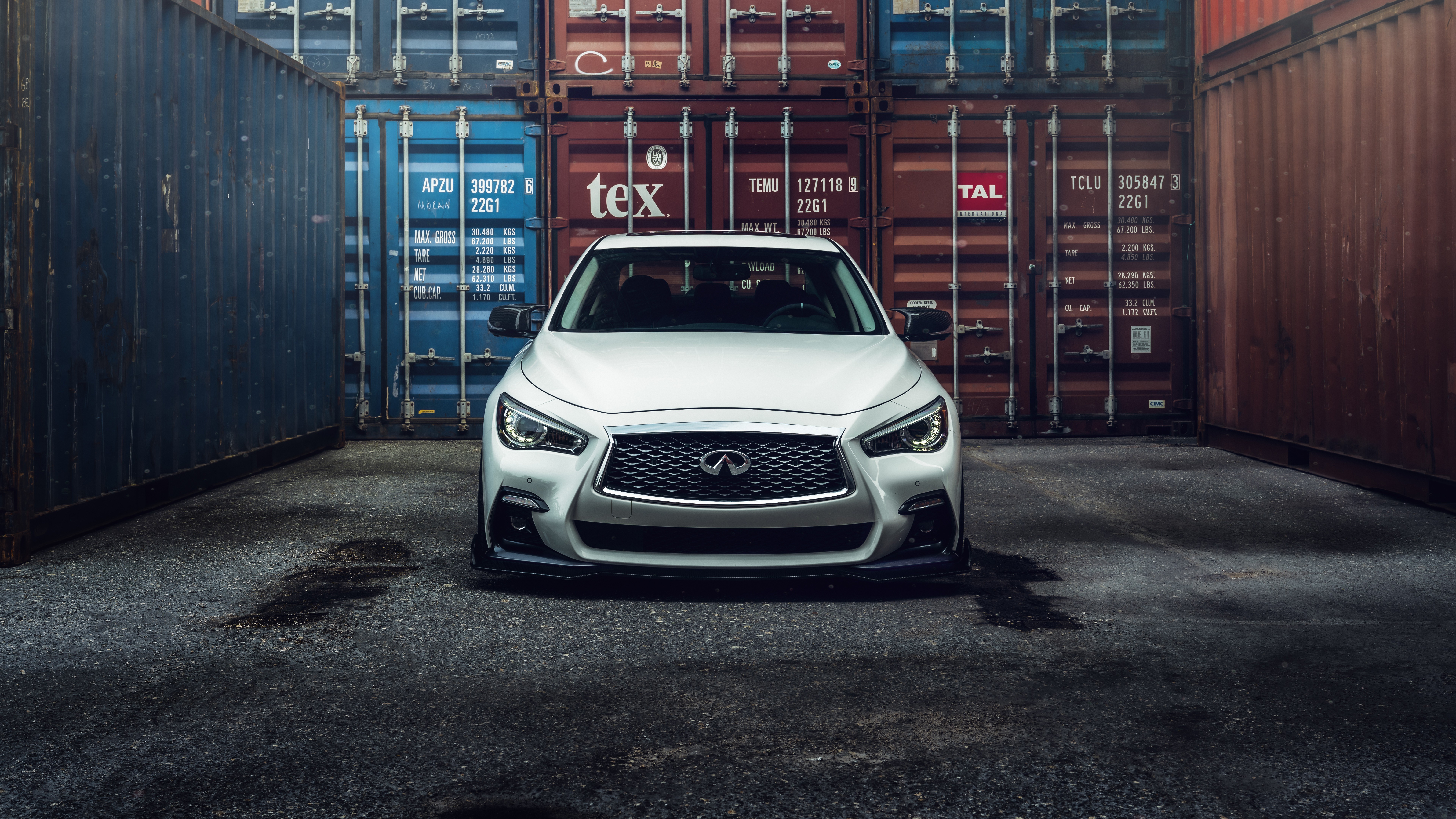 White Infiniti Q50 parked between shipping containers HD Wallpaper