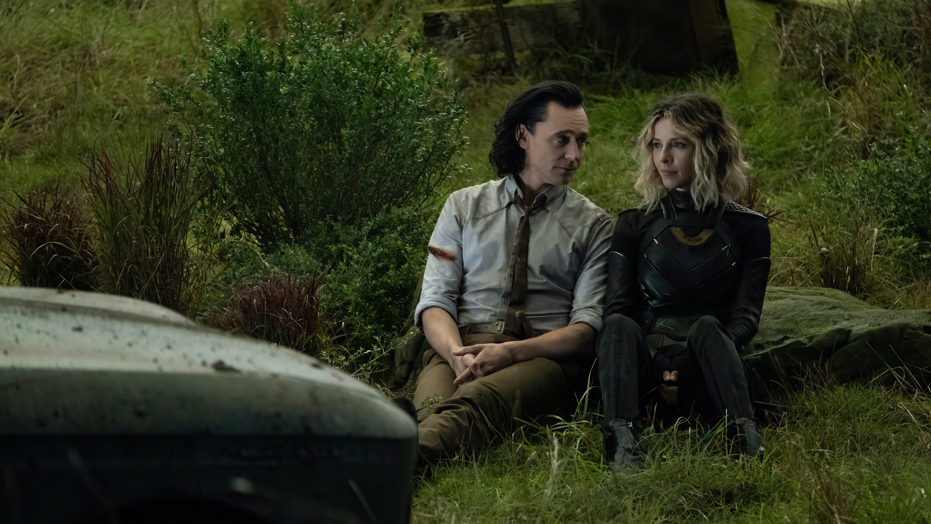 Loki and Sylvie sitting in a grassy field HD Wallpaper