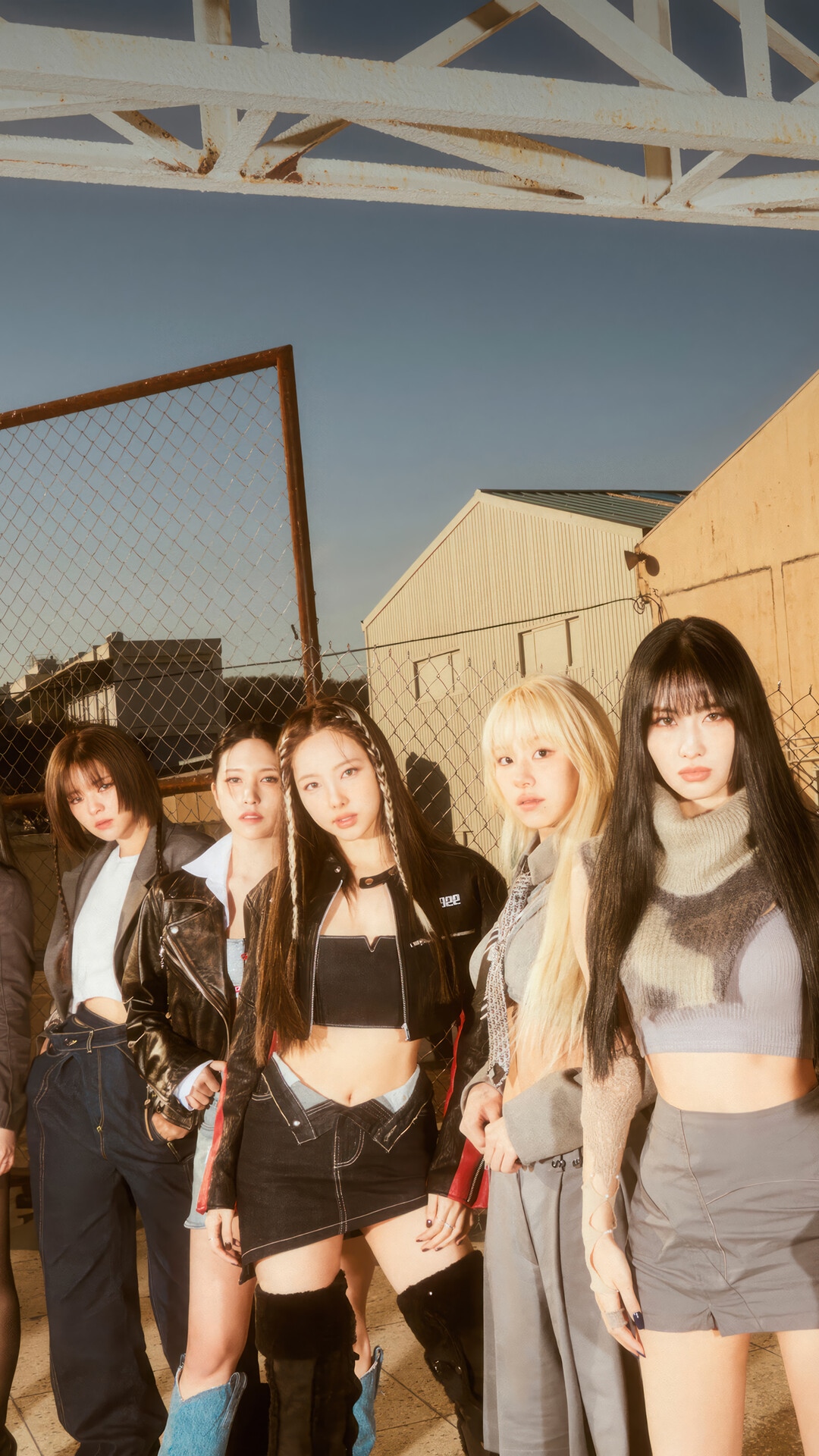 TWICE members posing in an outdoor industrial setting HD Phone Wallpaper