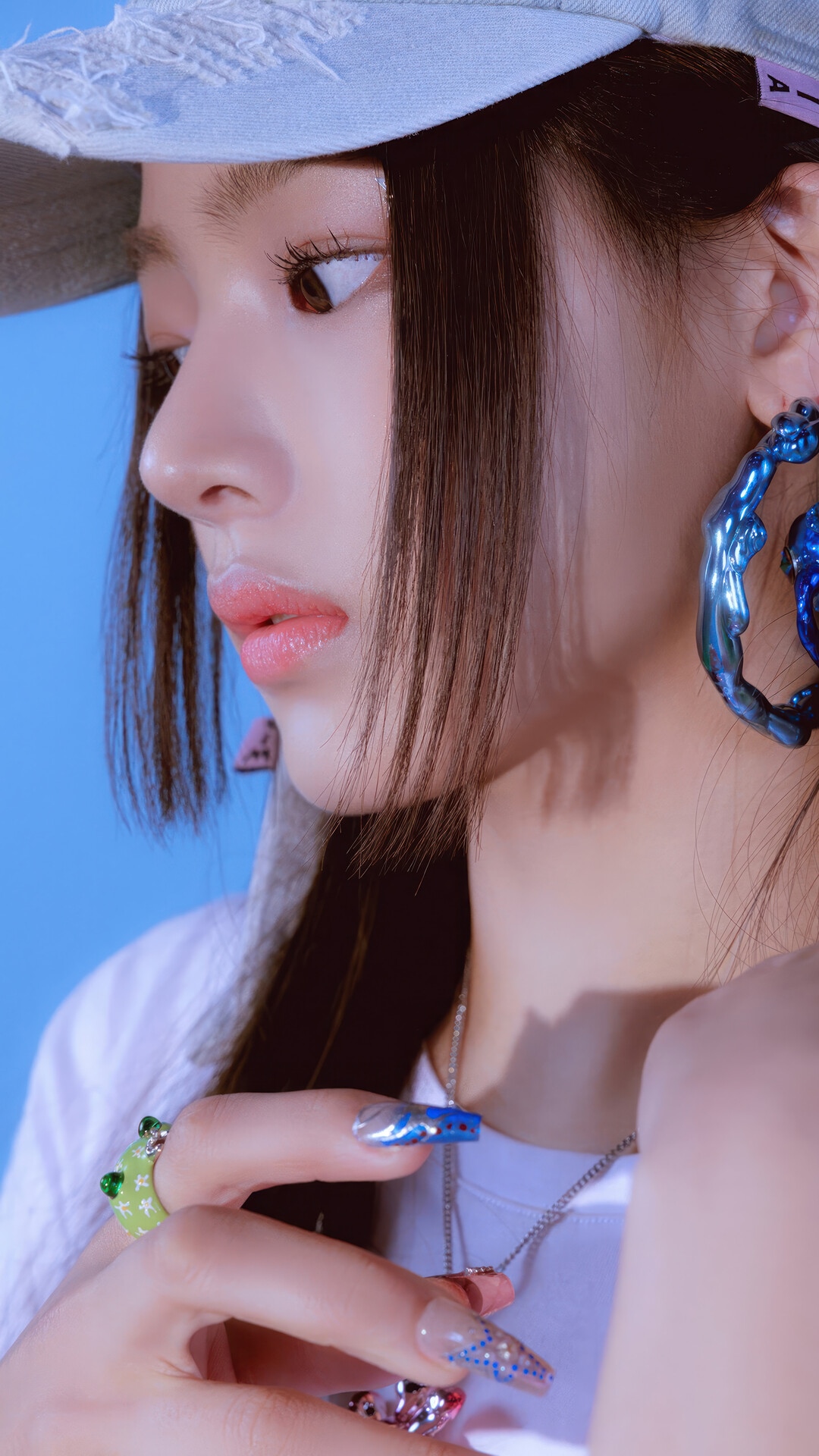 Minji from NewJeans wearing a blue earring and frog ring HD Phone Wallpaper