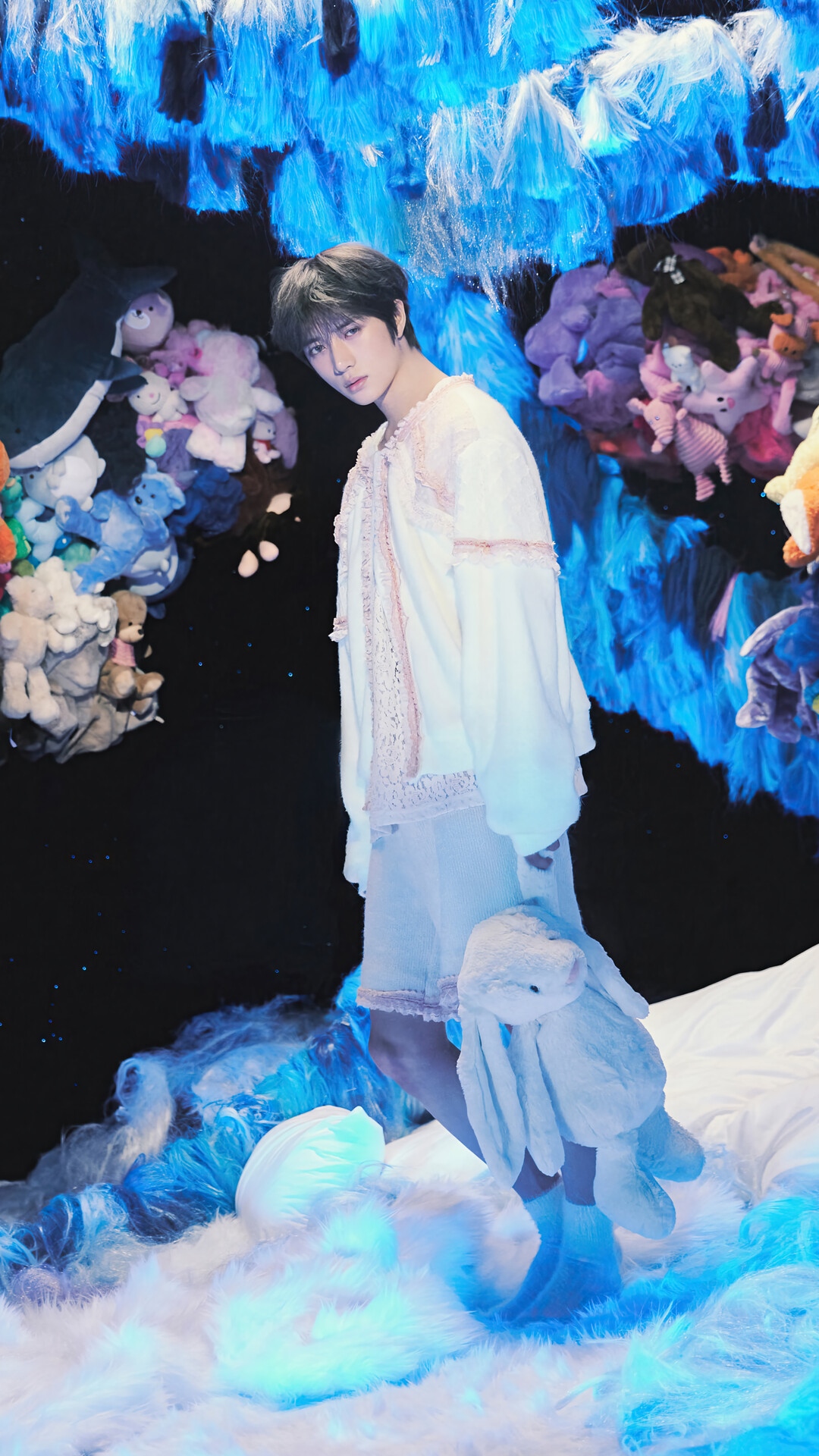 TXT Beomgyu with stuffed animals in a dreamlike setting HD Phone Wallpaper