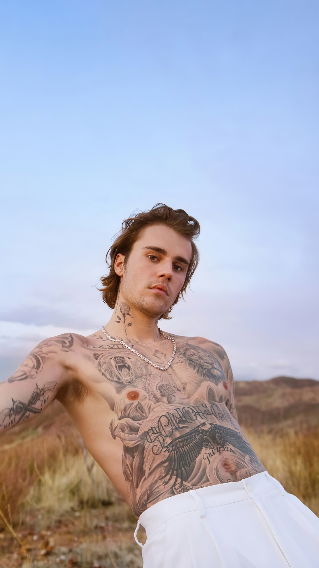 Justin Bieber shirtless with tattoos in a field HD Phone Wallpaper