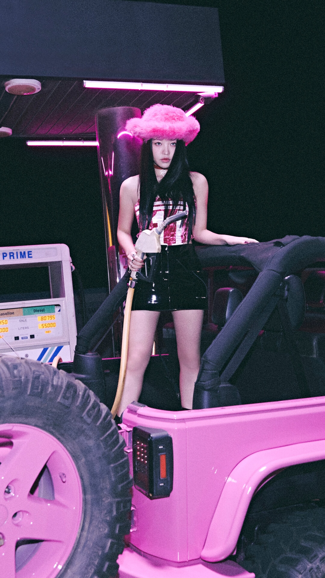 Yeri in a pink hat holding a gas pump nozzle HD Phone Wallpaper