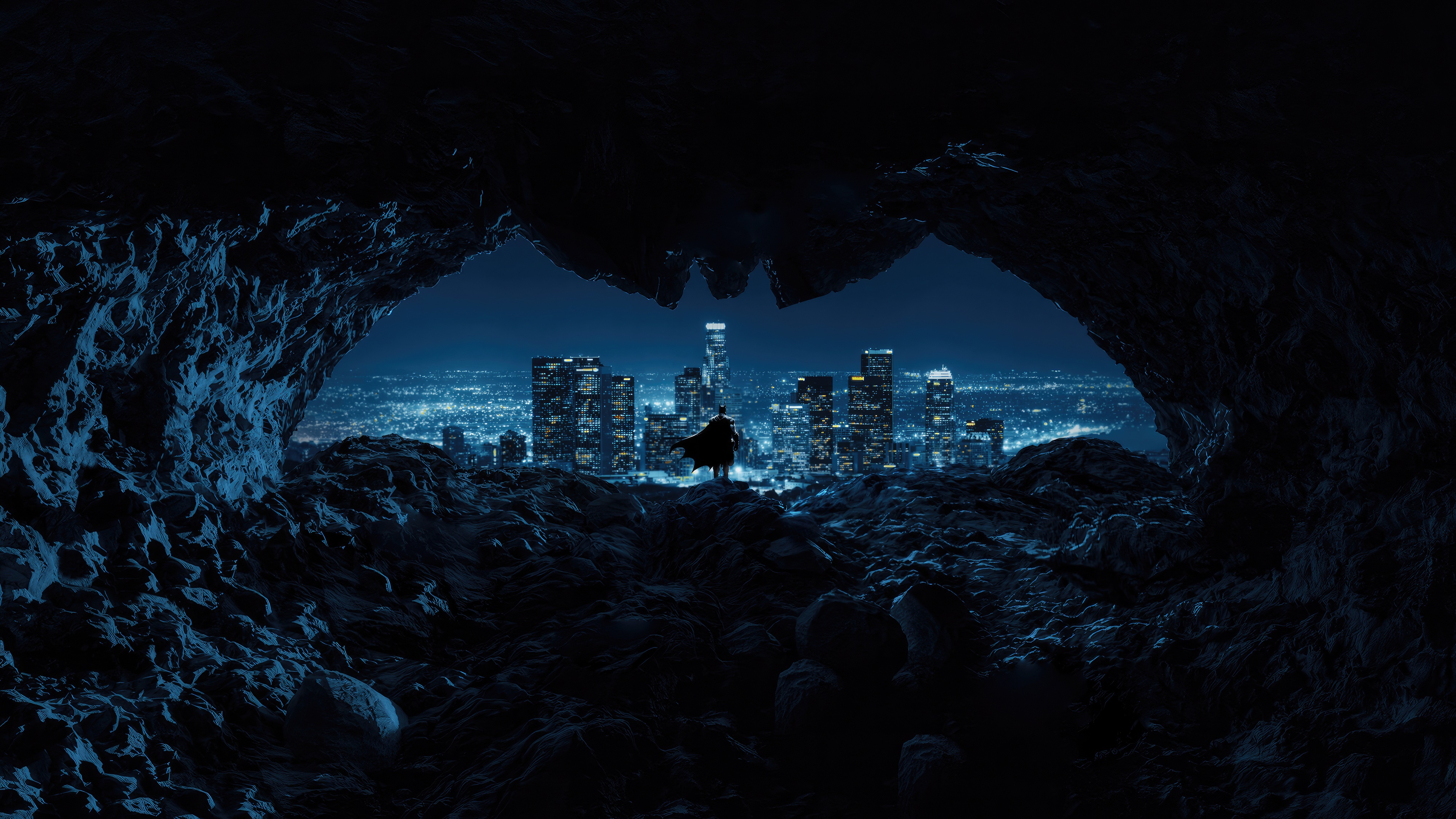 Batman overlooking a city from a cave HD Wallpaper