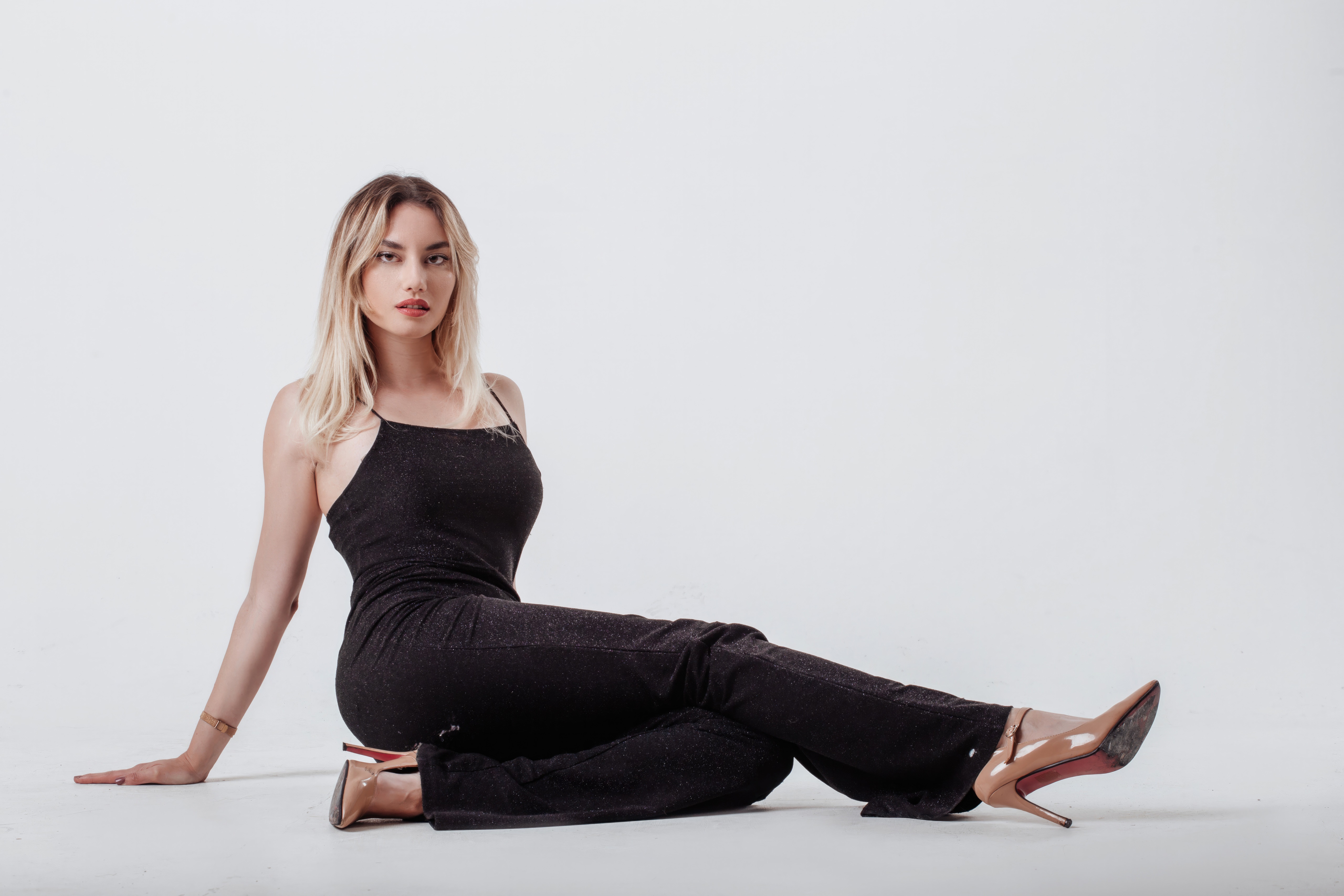 Model in black dress sitting on white background HD Wallpaper