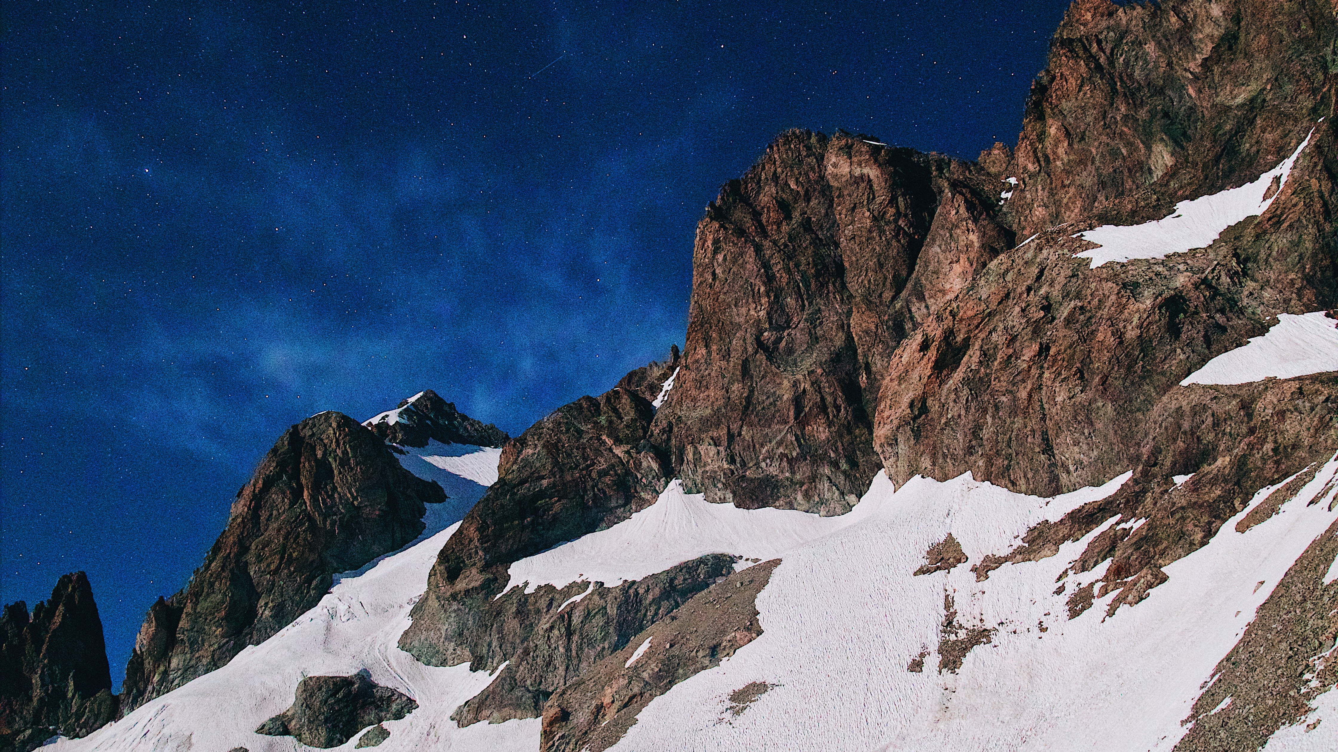 Snowy mountains under a starry night sky 4K HD Wallpaper